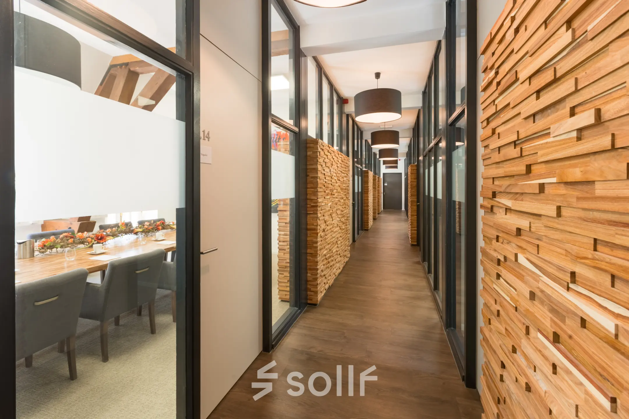 Modern office hallway at Blokstallen 2B, Bergen op Zoom with wooden paneling and glass-walled meeting rooms available for rent. Ideal office to rent for business operations.