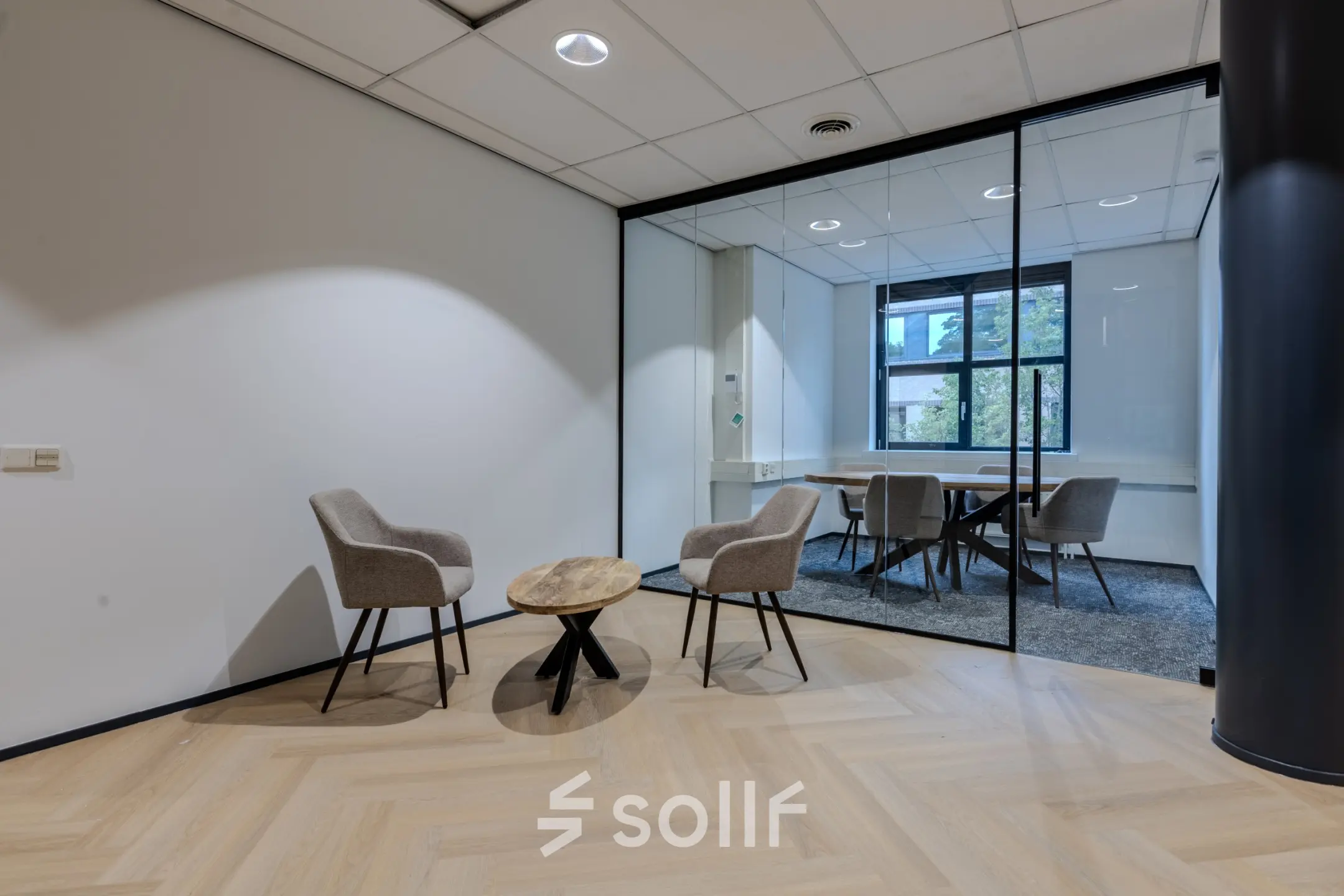 Modern office space to rent at Rijtuigweg 10, Bergen op Zoom, featuring a small seating area with two chairs and a table.