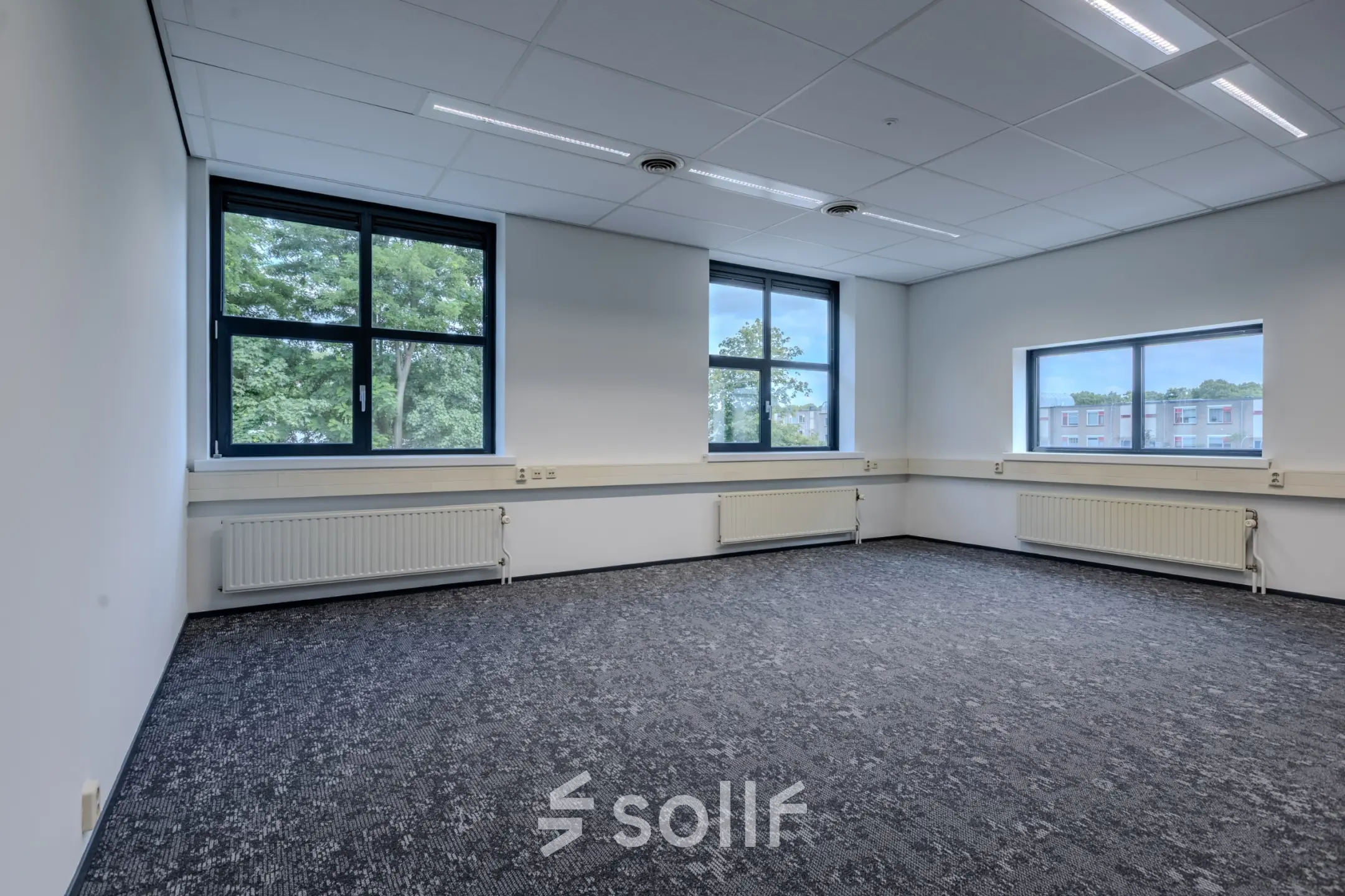 Unfurnished office space with large windows and patterned carpeting at Rijtuigweg 10, Bergen op Zoom, available for rent.