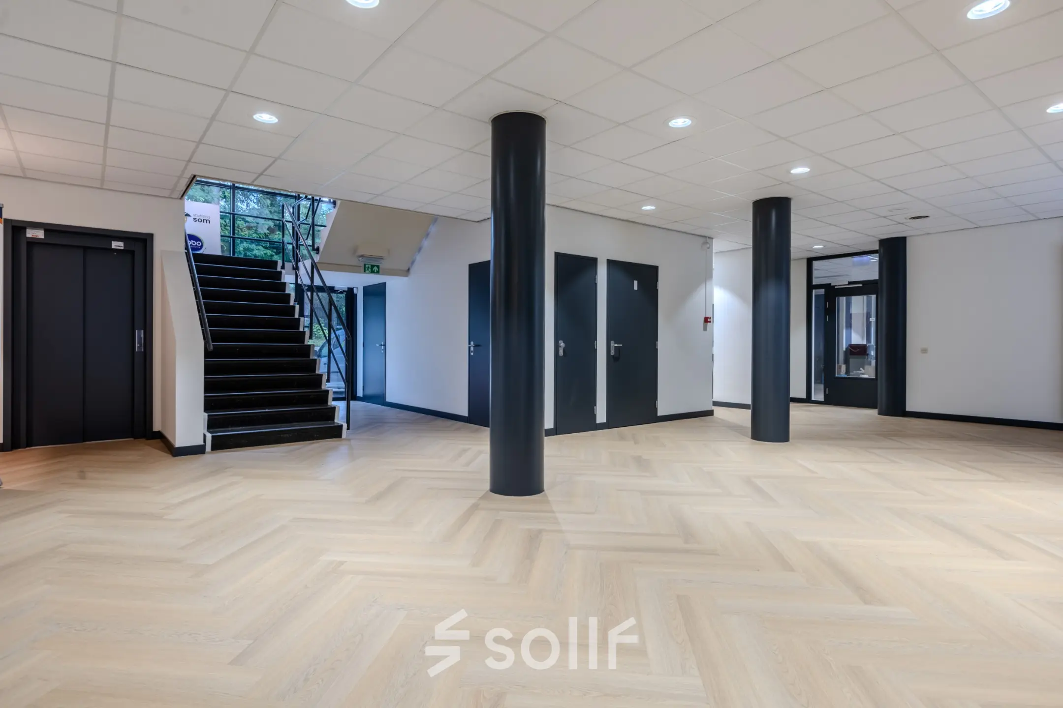 Spacious interior of an office for rent at Rijtuigweg 10, Bergen op Zoom with sleek columns and modern flooring.