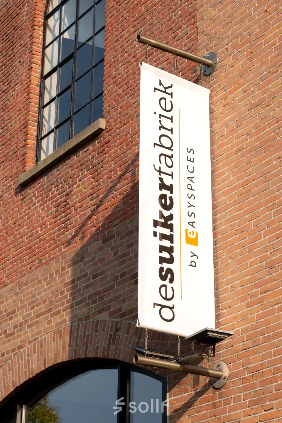Exterior view of office building at Zuidzijde Haven 39a, Bergen op Zoom, featuring a brick facade with a sign for desuikerfabriek by Easyspaces.