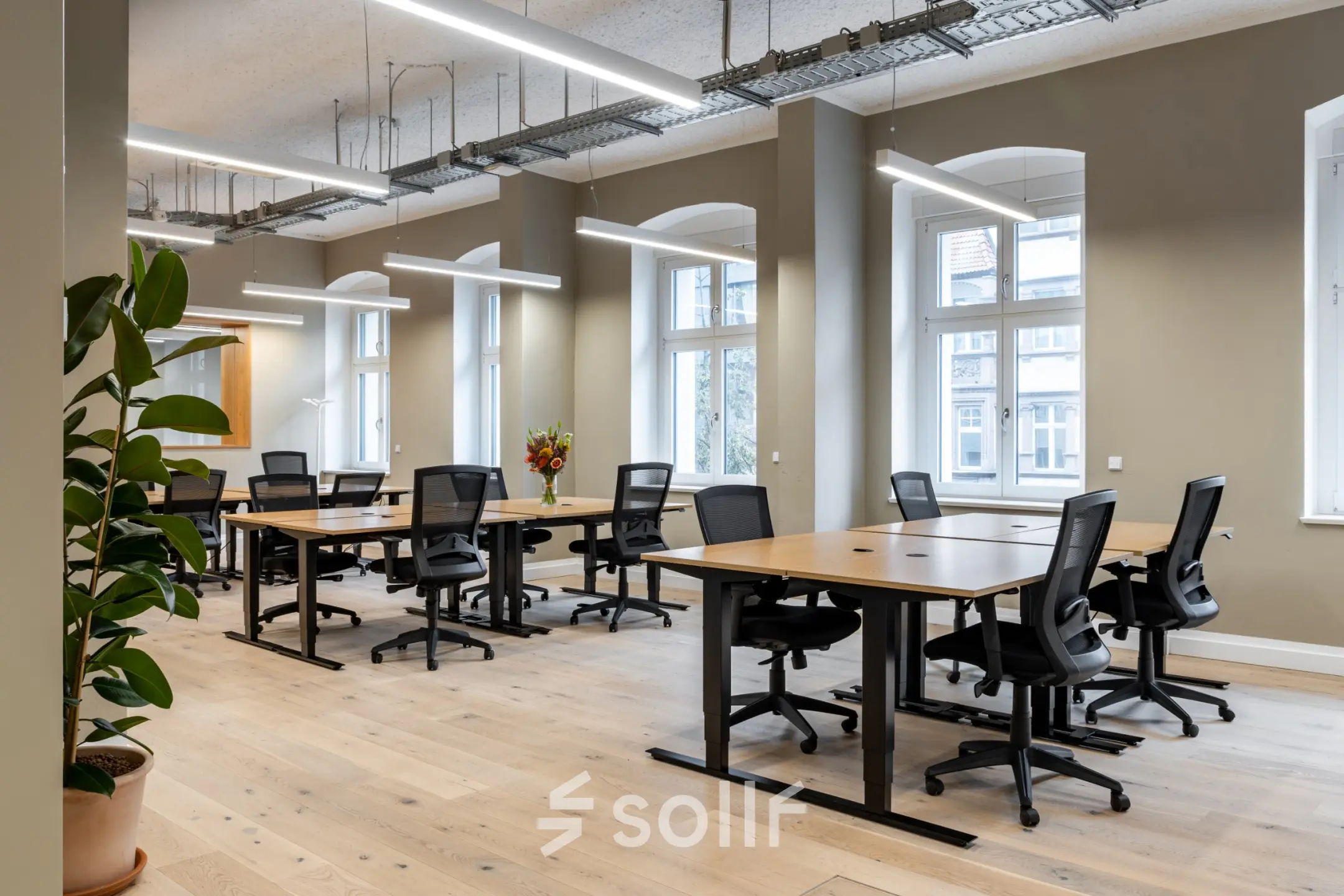 Furnished office space rental at Chausseestraße 29, Berlin Kreuzberg, featuring modern desks and chairs under bright lighting with large windows.