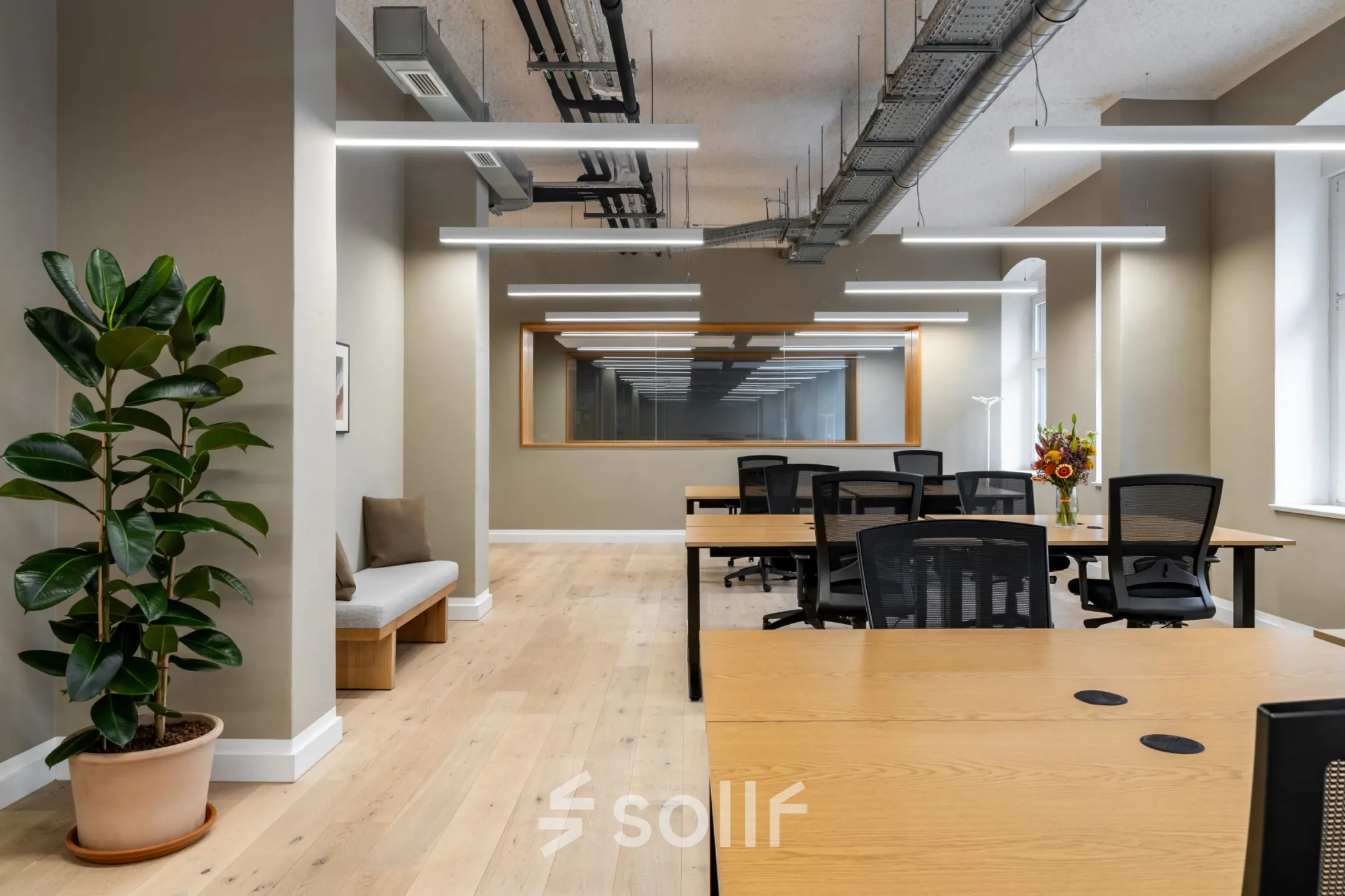 Interior view of a furnished office to rent at Chausseestraße 29, Berlin Kreuzberg, featuring modern desks and chairs arranged in a spacious layout.