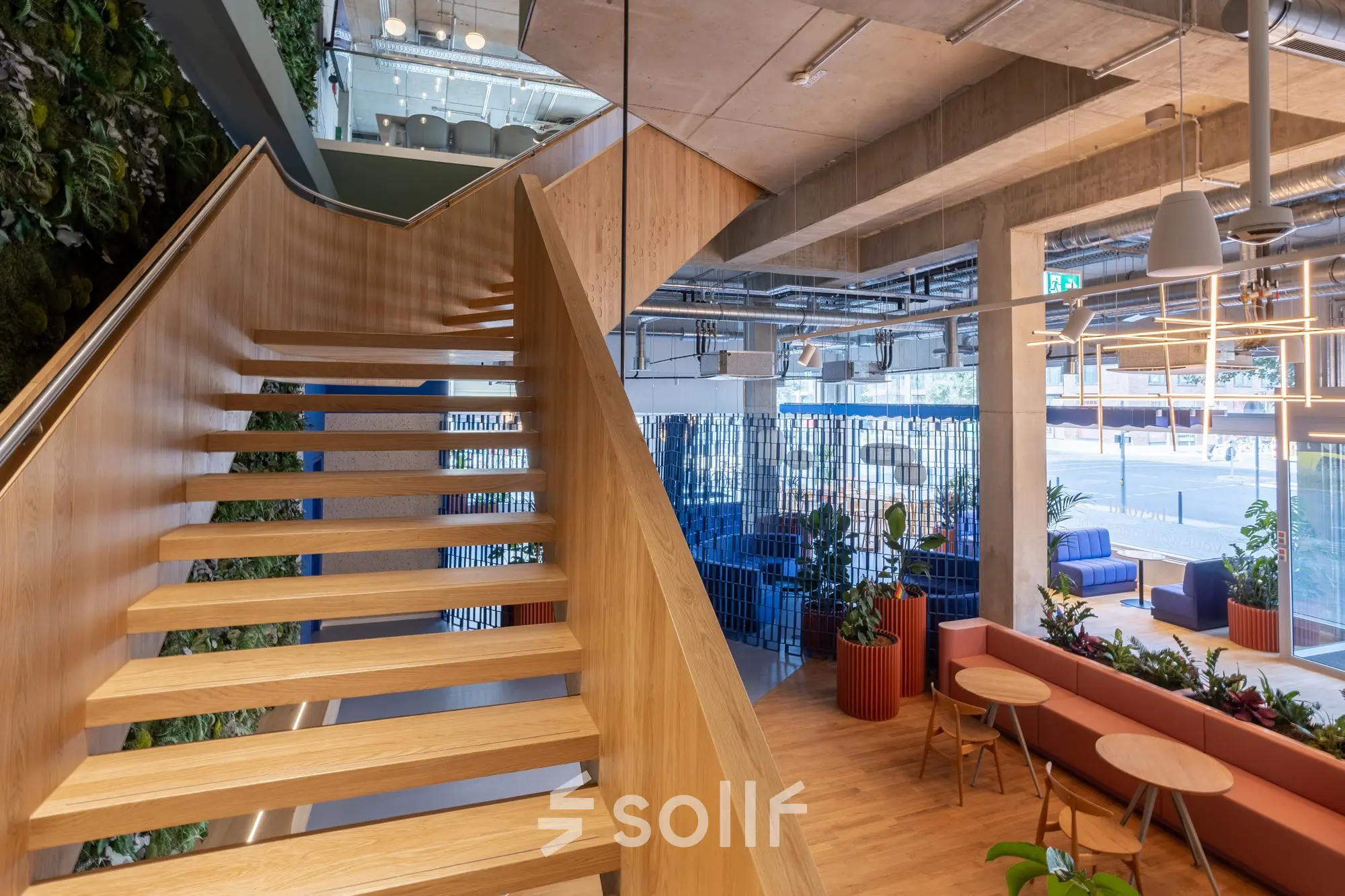 Stylish office interior at Heidestraße 34, Berlin Mitte, featuring a modern staircase and seating area ideal for casual meetings. Perfect for office space rental.