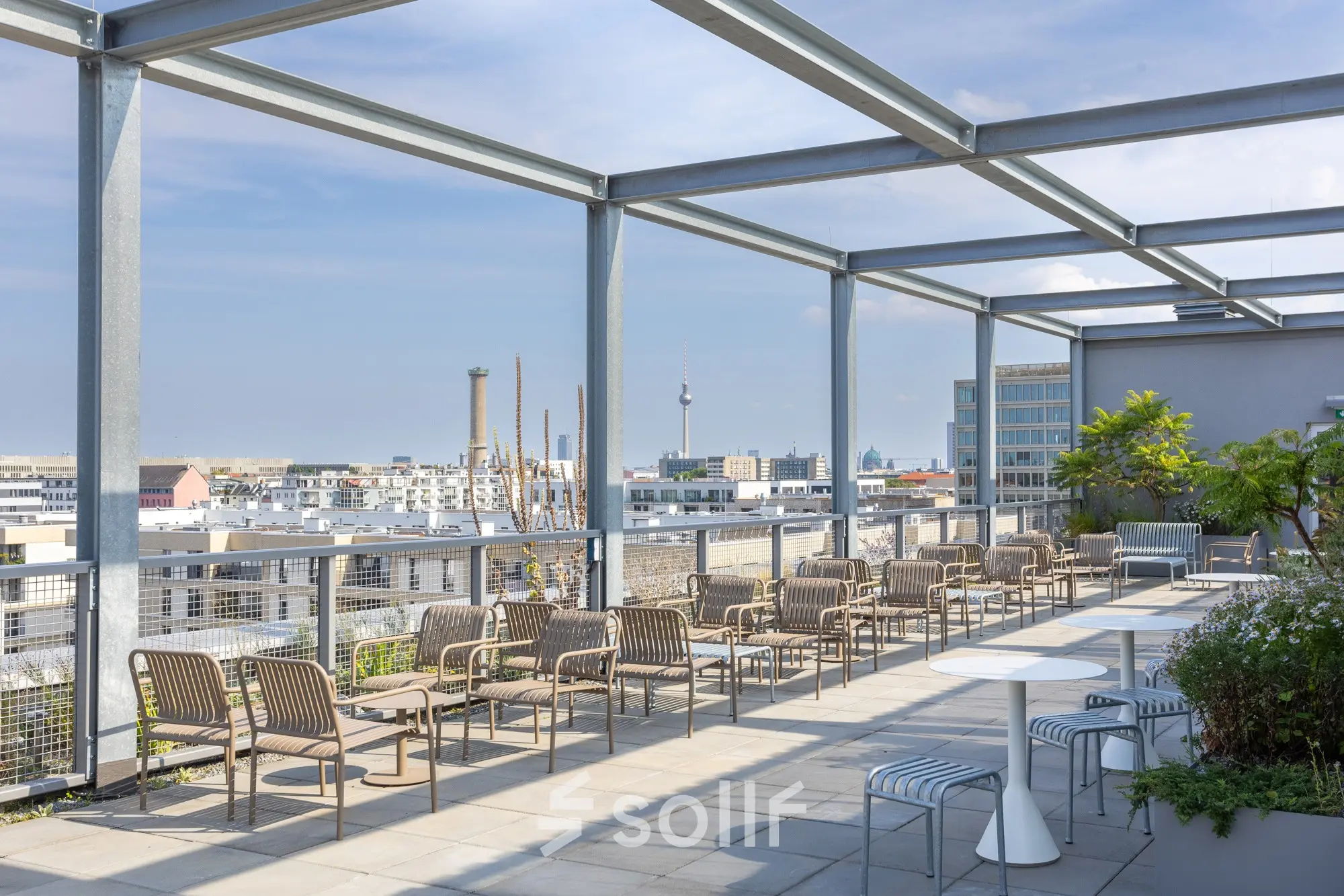 Rooftop office space at Heidestraße 34, Berlin Mitte, featuring outdoor seating with city views and ample daylight, perfect for informal meetings and networking.