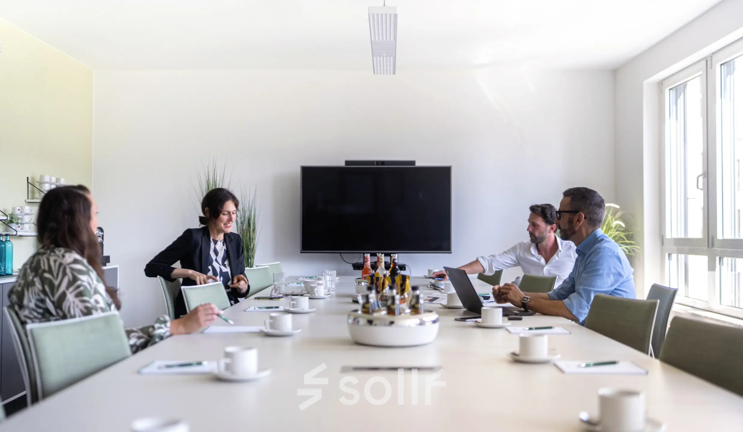Modern conference room at Leipziger Platz 15, Berlin Mitte, featuring a central table with people engaged in a meeting, highlighting prime office space rental opportunities.