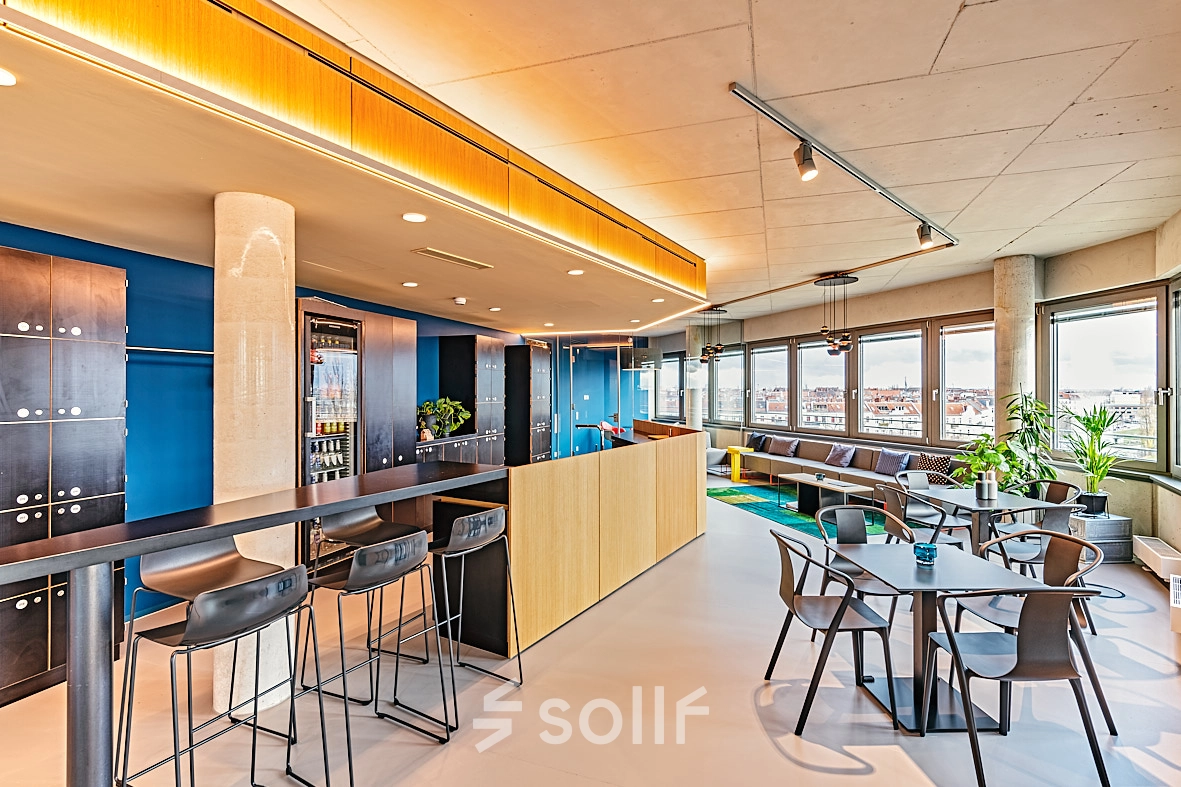 Modern office space for rent in Berlin Schöneberg at EUREF-Campus 22, featuring stylish furnishings, a mix of seating options, and expansive windows with natural light.