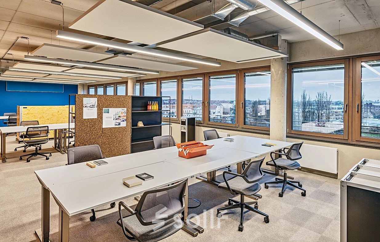 Bright office space at EUREF-Campus 22, Berlin Schöneberg, featuring ample desks and ergonomic chairs, ideal for business activities with a captivating view.