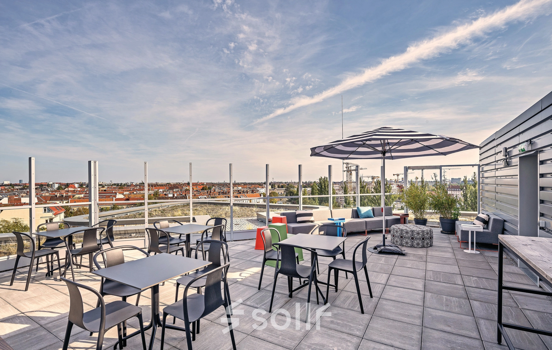 Modern rooftop terrace at EUREF-Campus 22 in Berlin Schöneberg, offering panoramic views and plentiful seating, ideal for informal meetings. An attractive option for office space rental.
