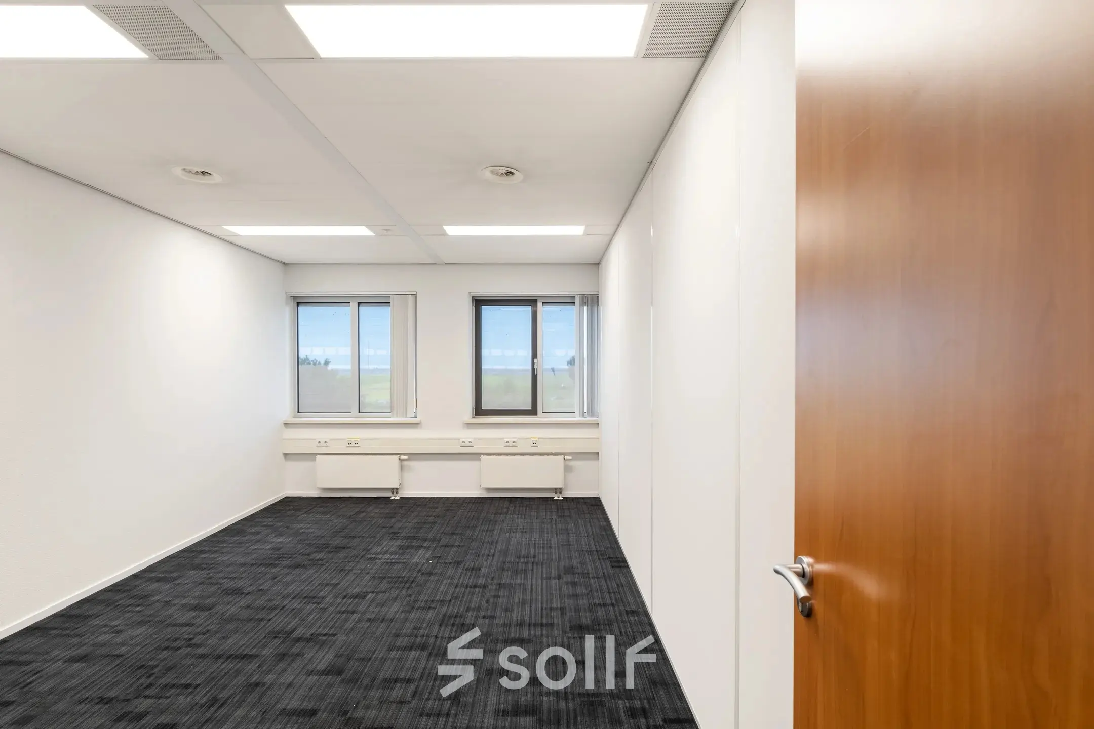 Bright and empty office space available for rent at Tolnasingel 1 - 3, Bodegraven. Features carpeted floors and large windows.