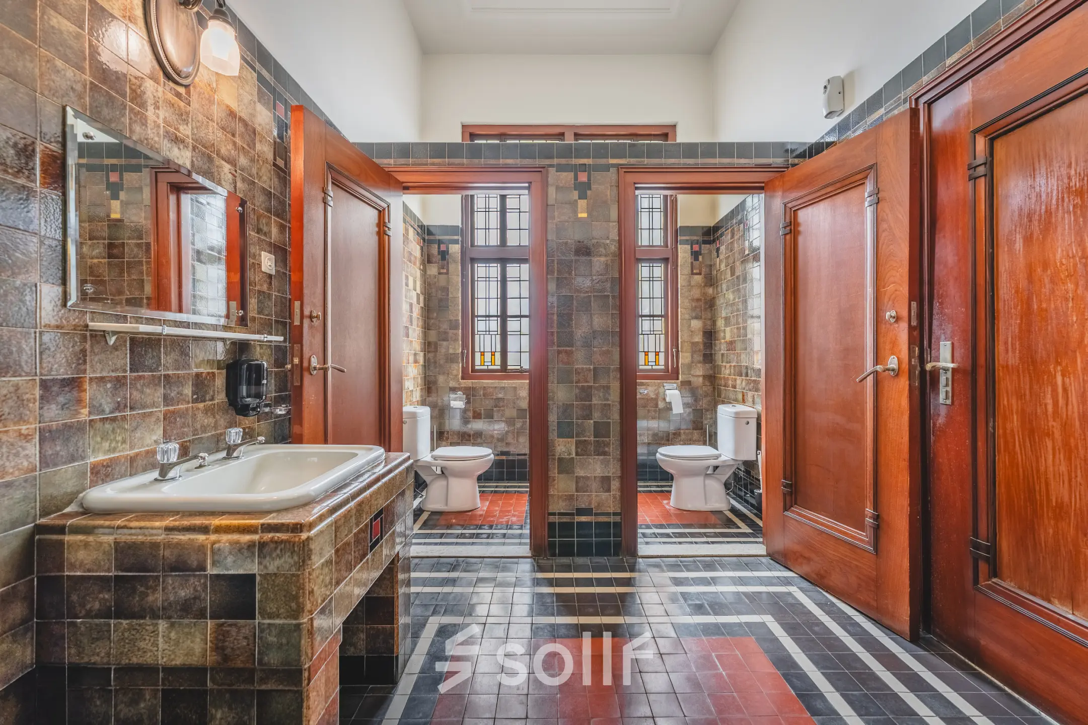 A restroom at Ceresstraat 13, Breda Centrum-Station featuring a vintage tile design and wooden doors, suitable for office space rental needs.