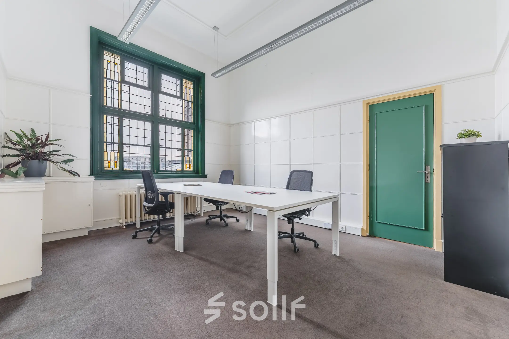 Bright office space with modern furnishings, featuring large windows and a simple, clean design, ideal for office space rental in Breda Centrum-Station.