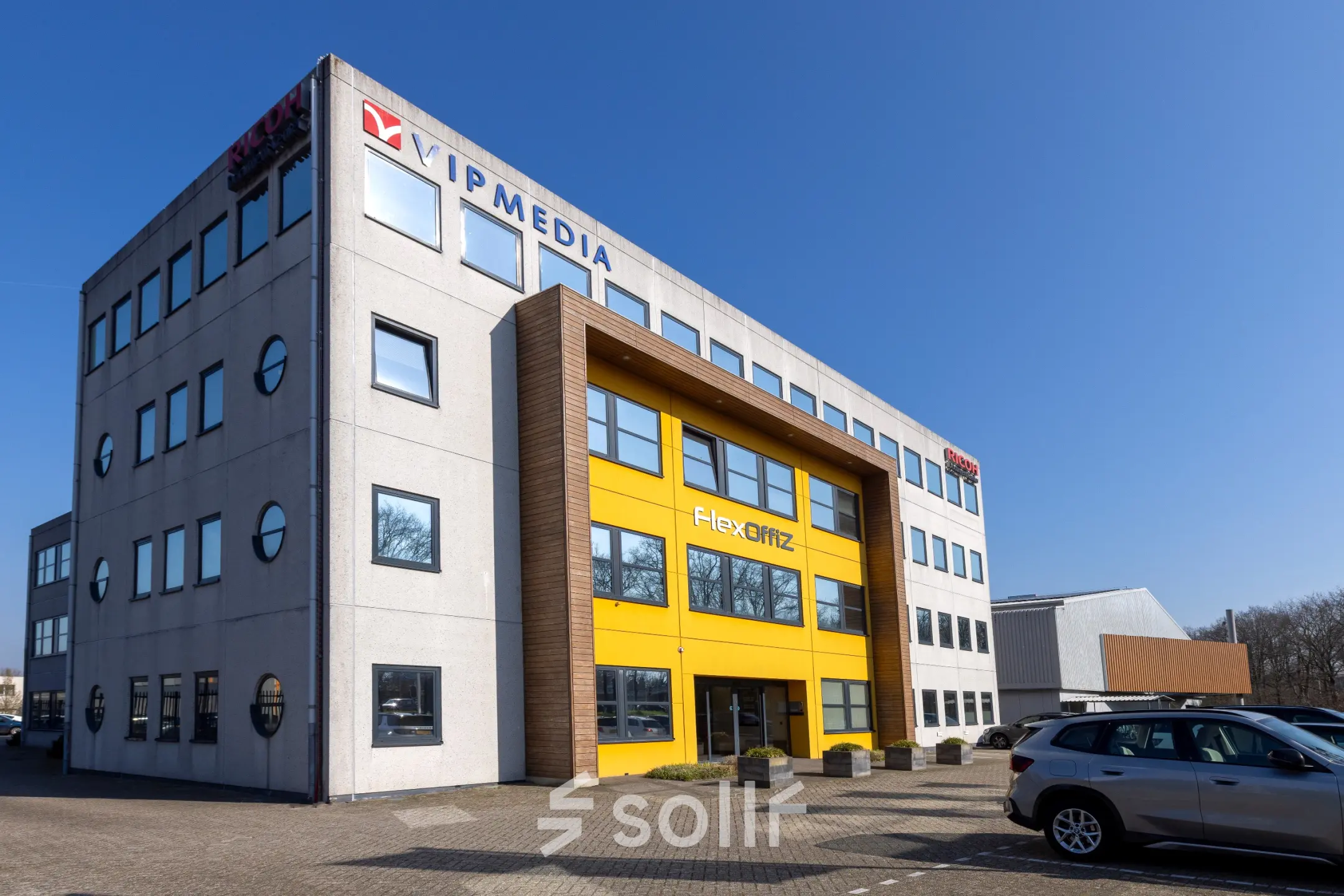 Exterior view of the office building at Takkebijster 57A, Breda Oost-Brabantpark, showcasing a modern facade and parking area available for office space rental.
