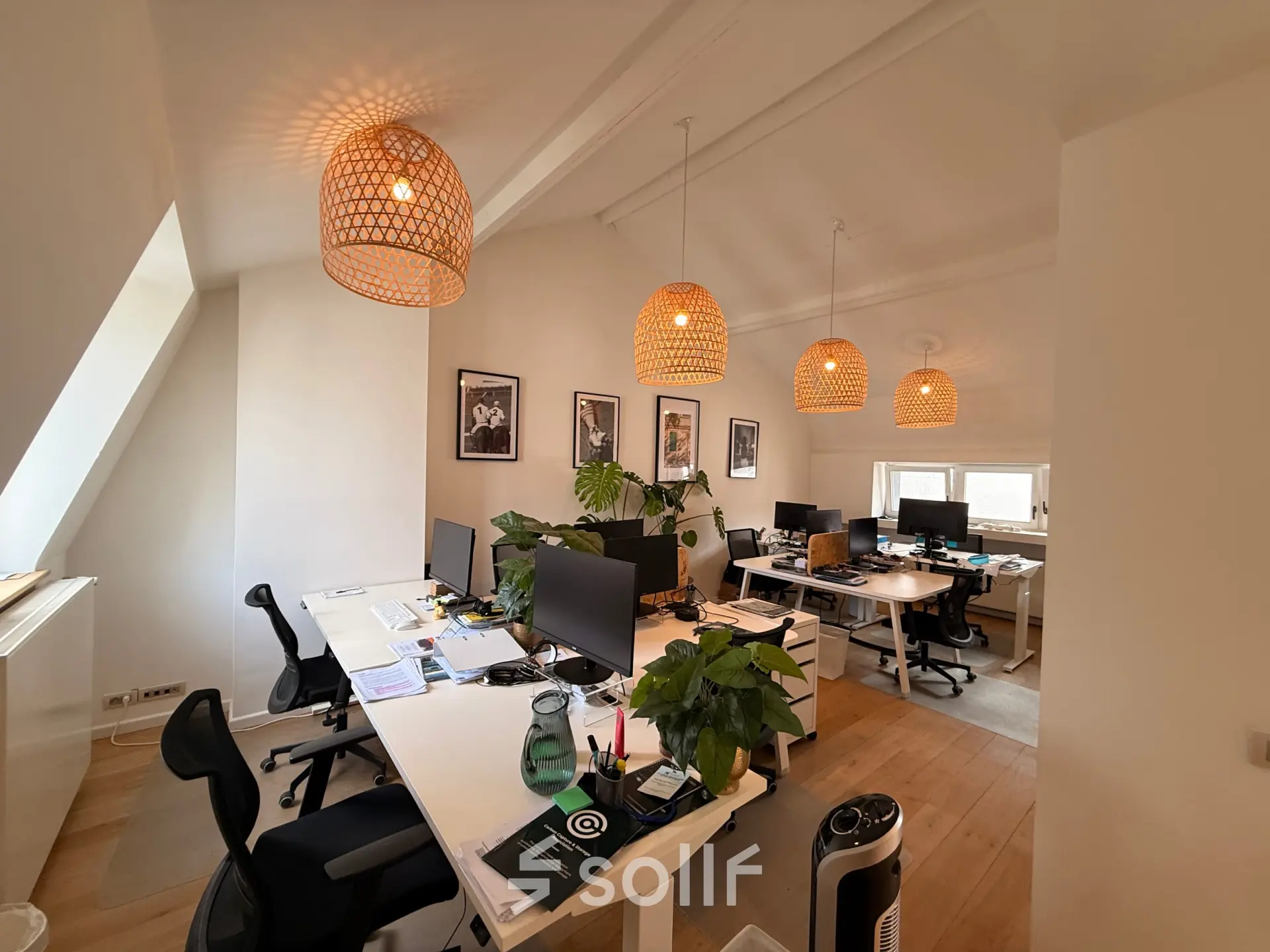 Well-lit office space with modern workstations and stylish lighting in Brussels Center, ideal for office space rental.