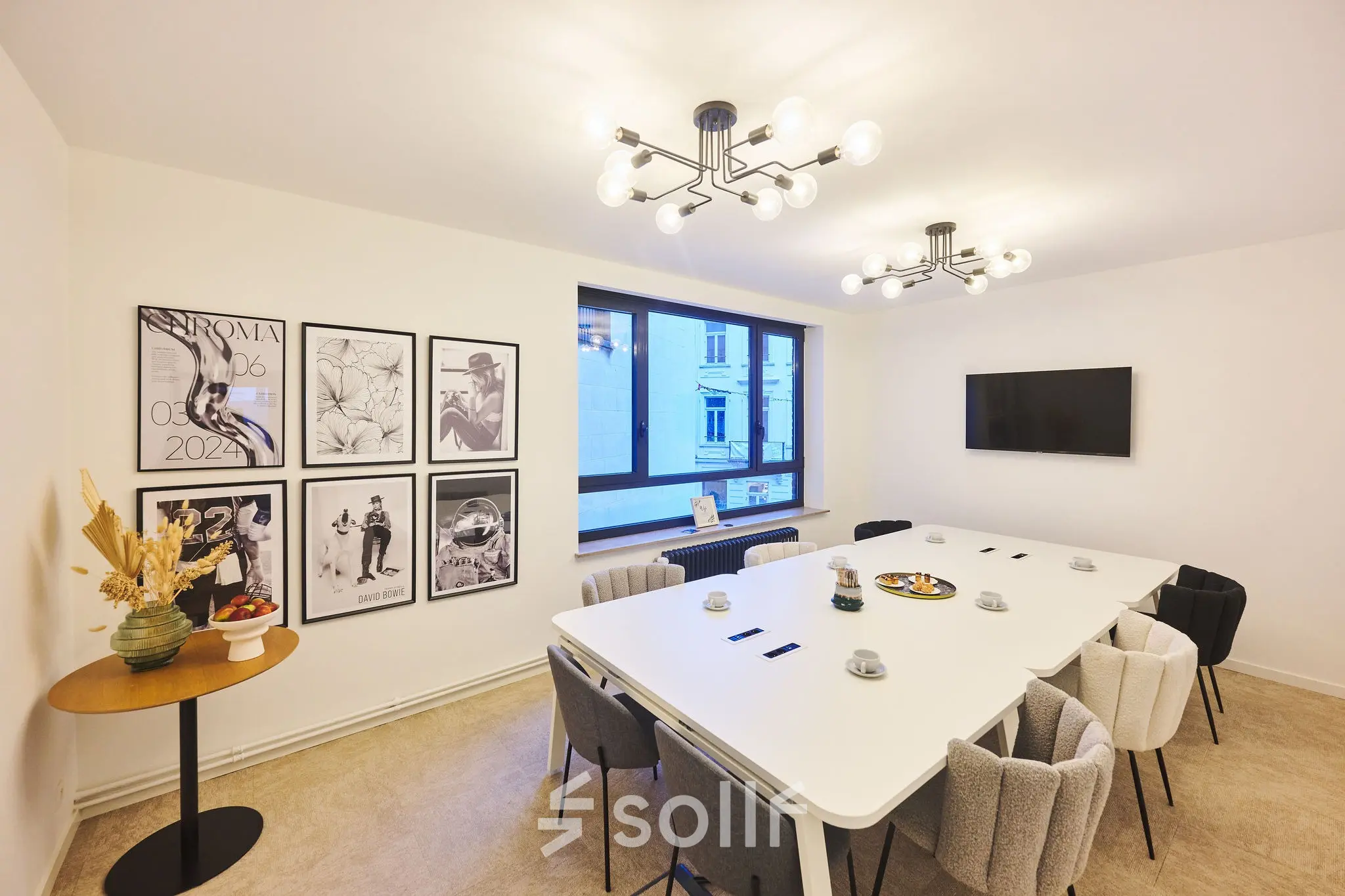Modern conference room at Rue du Congres 37, Brussels Center, ideal for office space rental, featuring a long table, chairs, and wall art.