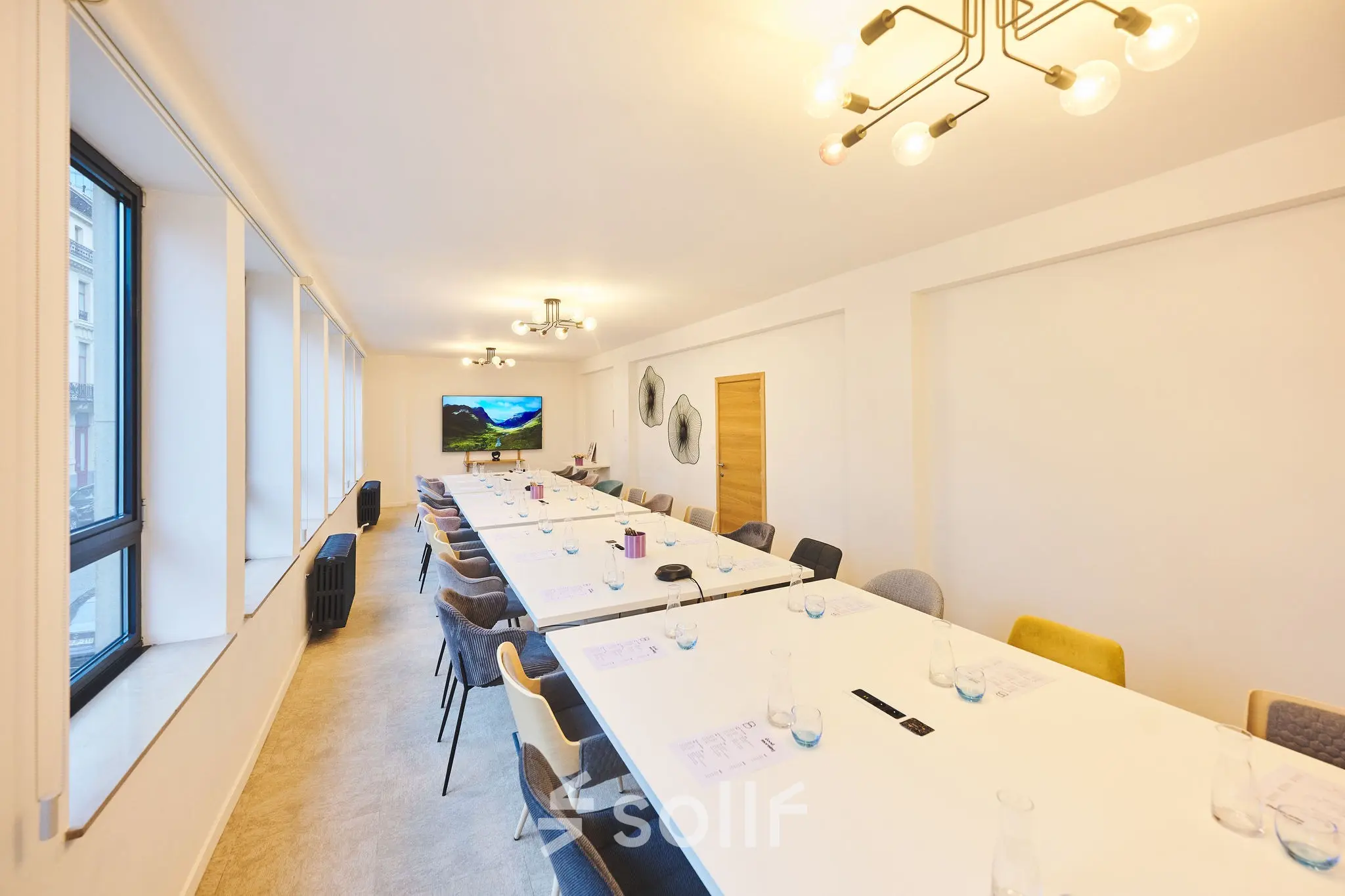 Spacious conference room at Rue du Congres 37, Brussels Center, featuring modern lighting and long tables ideal for office space rental.