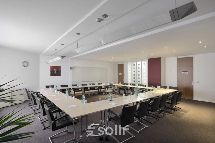 Spacious conference room at Louizalaan/Avenue Louise 65 in Brussels Elsene with a large table and chairs set up for a meeting, ideal for office space rental.