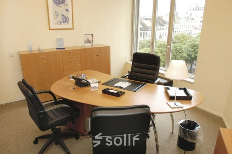 Bright office space with two chairs facing a large desk and a window view at Louizalaan / Avenue Louise 65, ideal for office space rental.