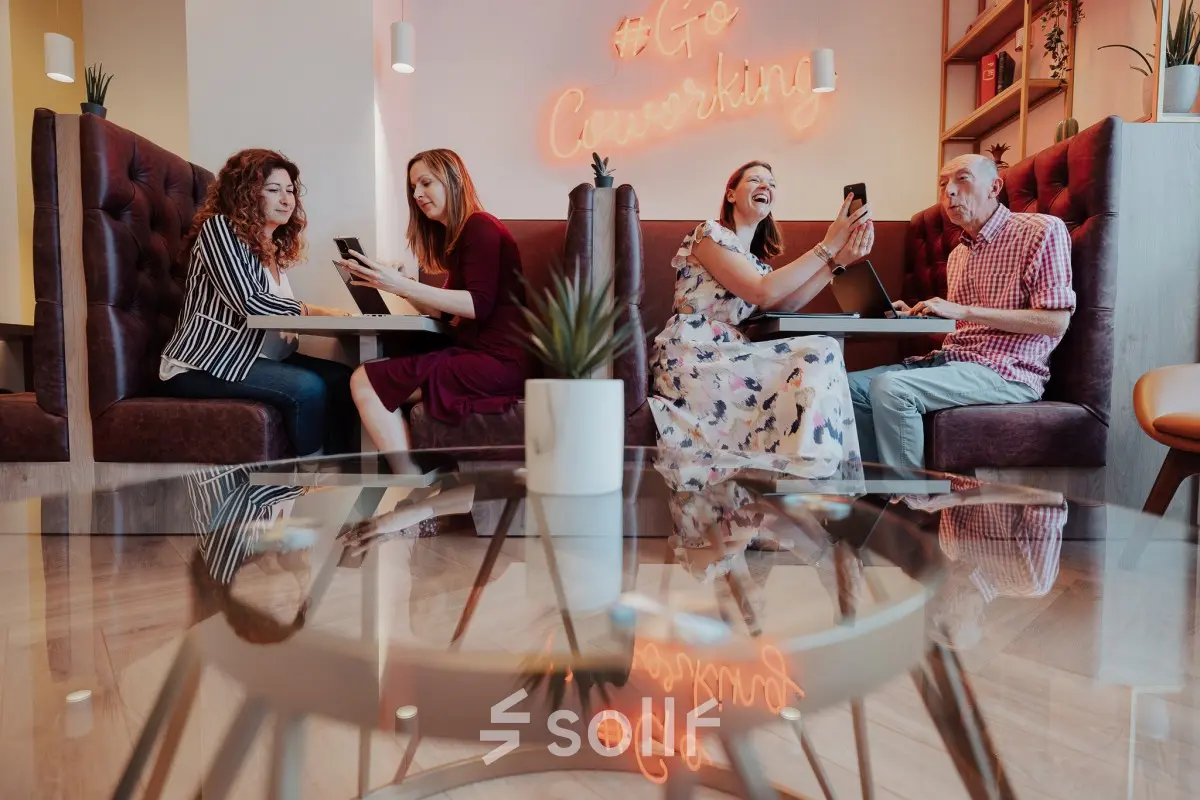 Cozy coworking area at Robert Schumanplein 2-4, Brussels European District with people engaged in discussions, ideal for office space rental.