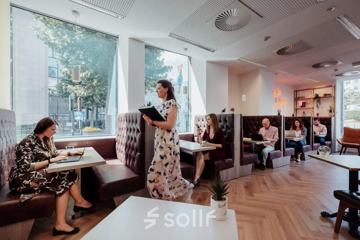 Modern office space in Brussels European District at Robert Schumanplein 2-4 with people working in comfortable booths, ideal for office space rental.