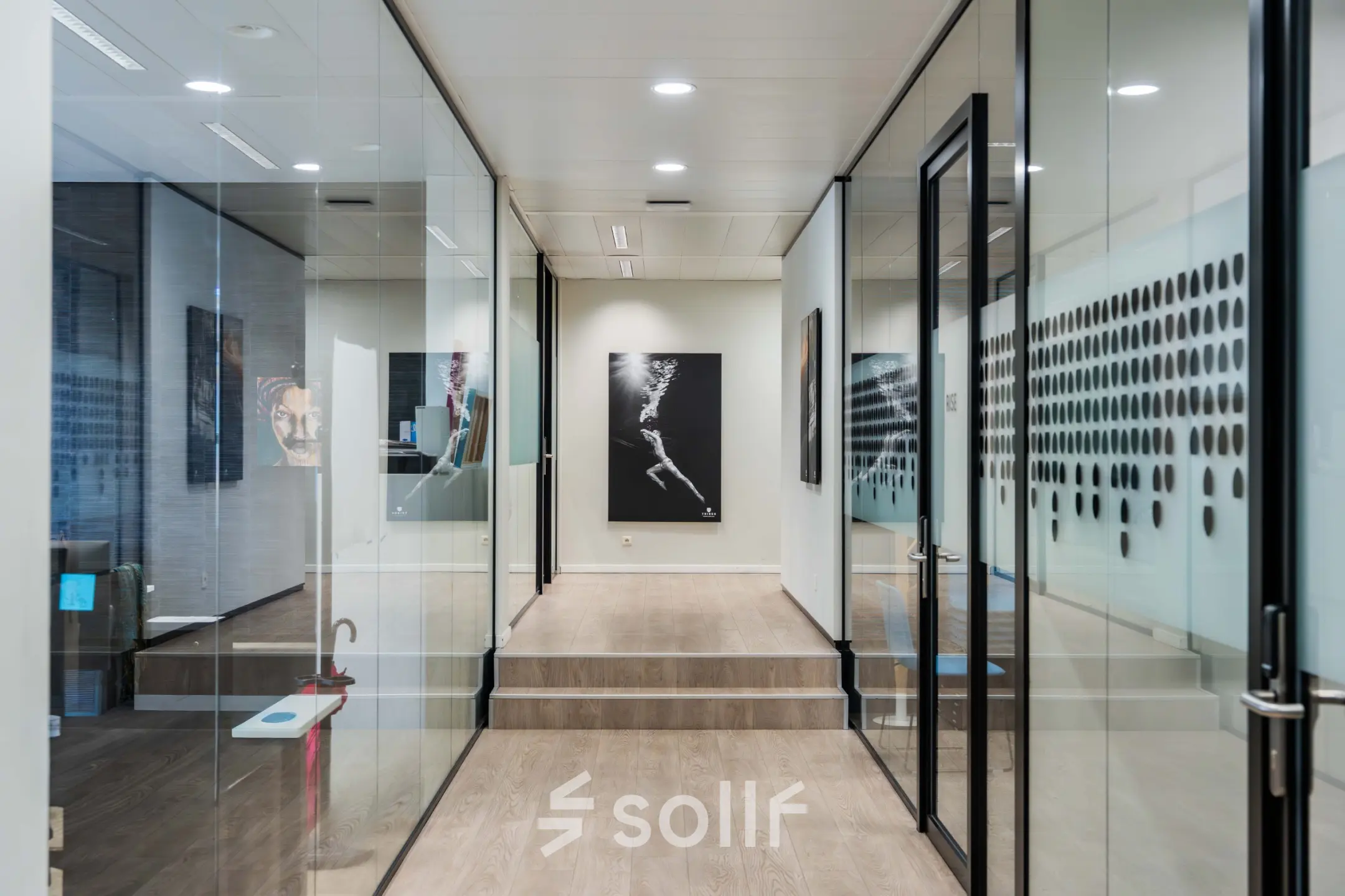 Modern office space at Rue des Colonies 56, Brussels European District featuring glass-walled workspaces and contemporary art, ideal for rent office space seekers.