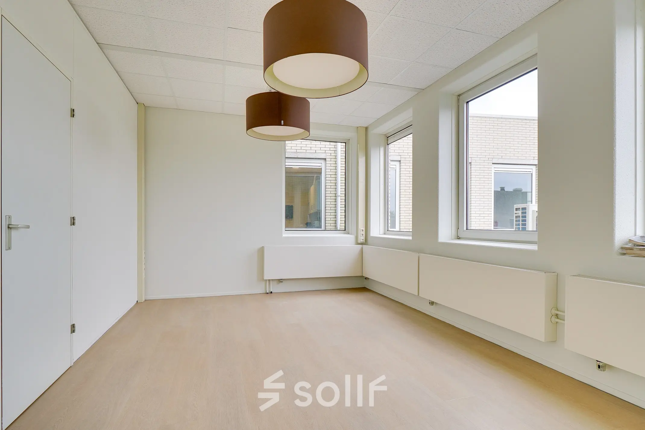 Bright, unfurnished office space at Regulierenring 2, Bunnik, available for rent with large windows and modern lighting fixtures.