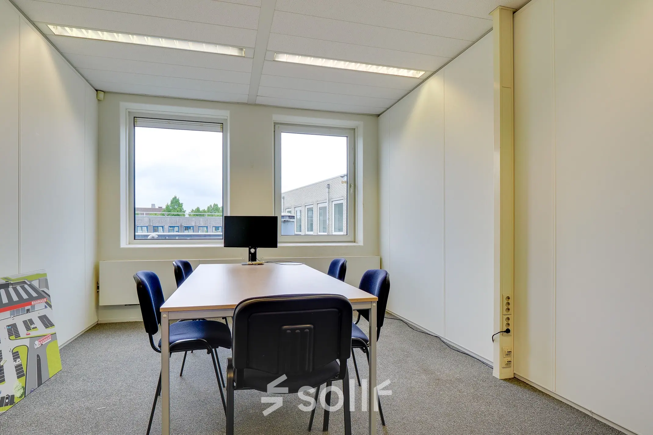 Bright office space at Regulierenring 2, Bunnik, featuring a table with chairs and a monitor in a well-lit environment, ideal for rent office space.