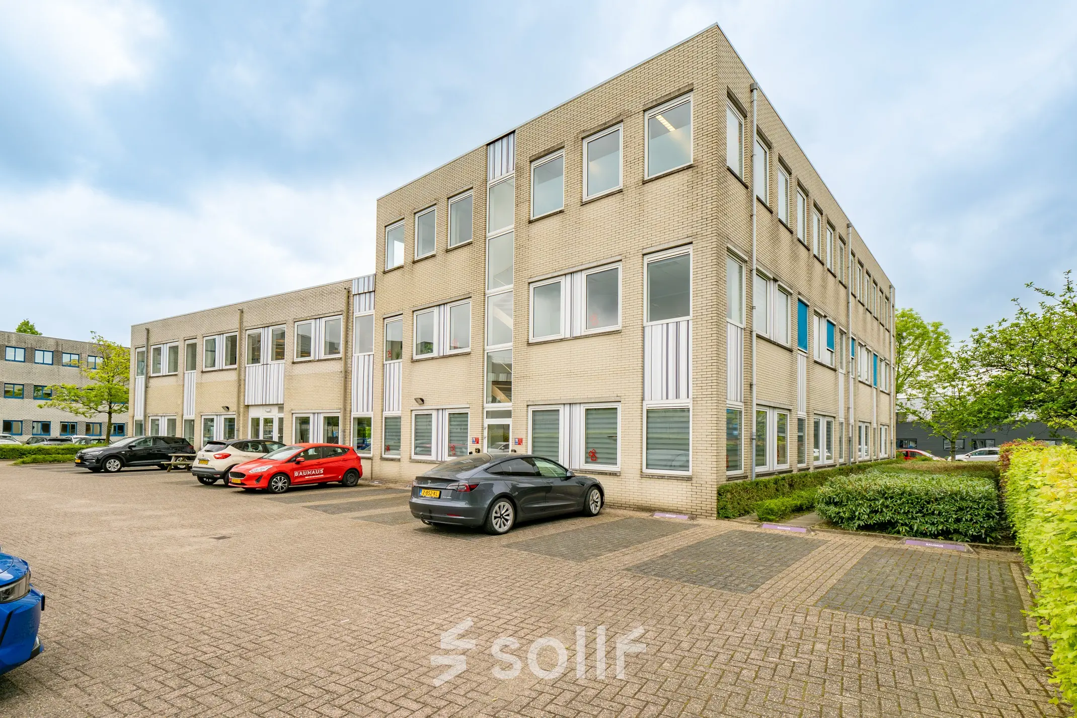 Exterior view of office building at Regulierenring 2, Bunnik with parking area for office space rental.