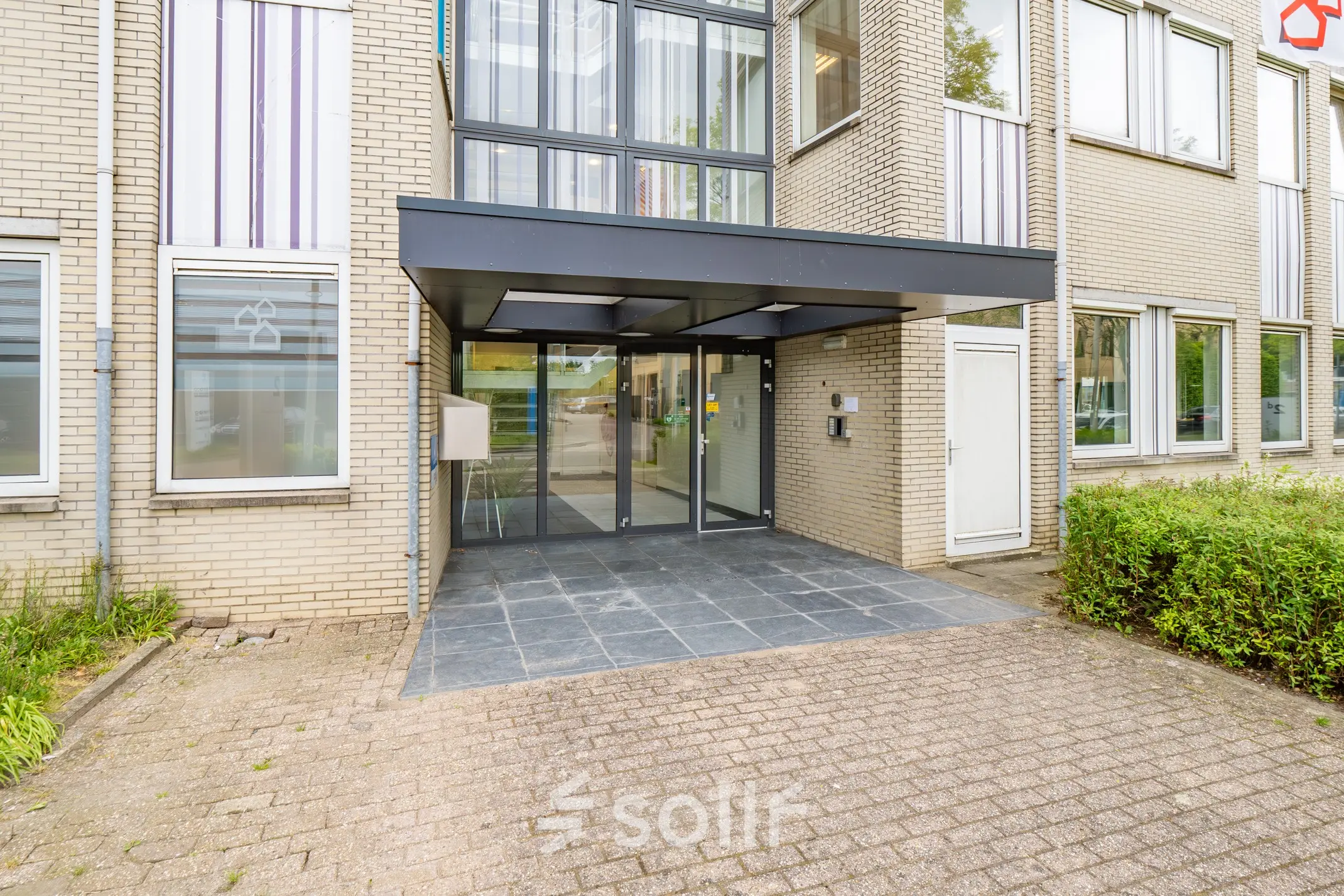 Entrance of office space at Regulierenring 2, Bunnik, available for rent, showing a modern glass entryway.