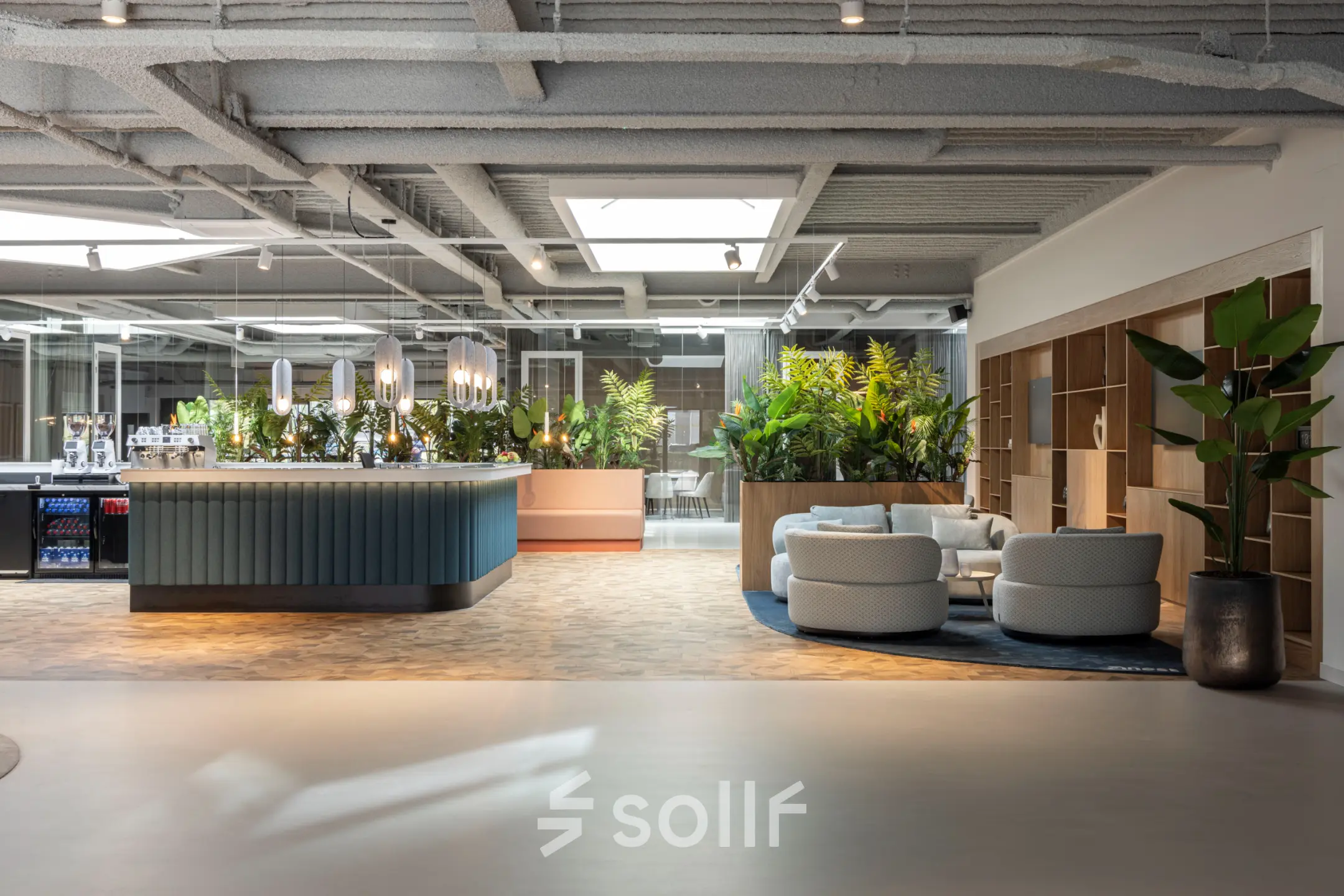 Modern office lounge at Essebaan 63, Capelle aan den IJssel, featuring stylish seating areas and lush greenery, ideal for office space rental and informal meetings.