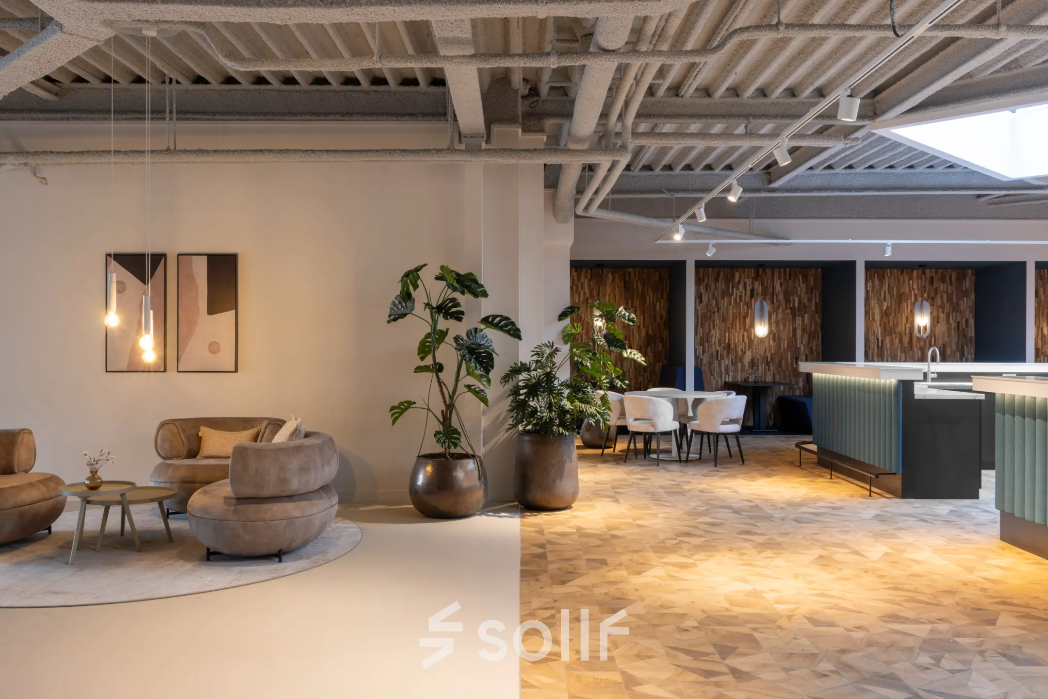 Modern office with stylish furnishings, featuring seating areas and plants, ideal for office space rental.