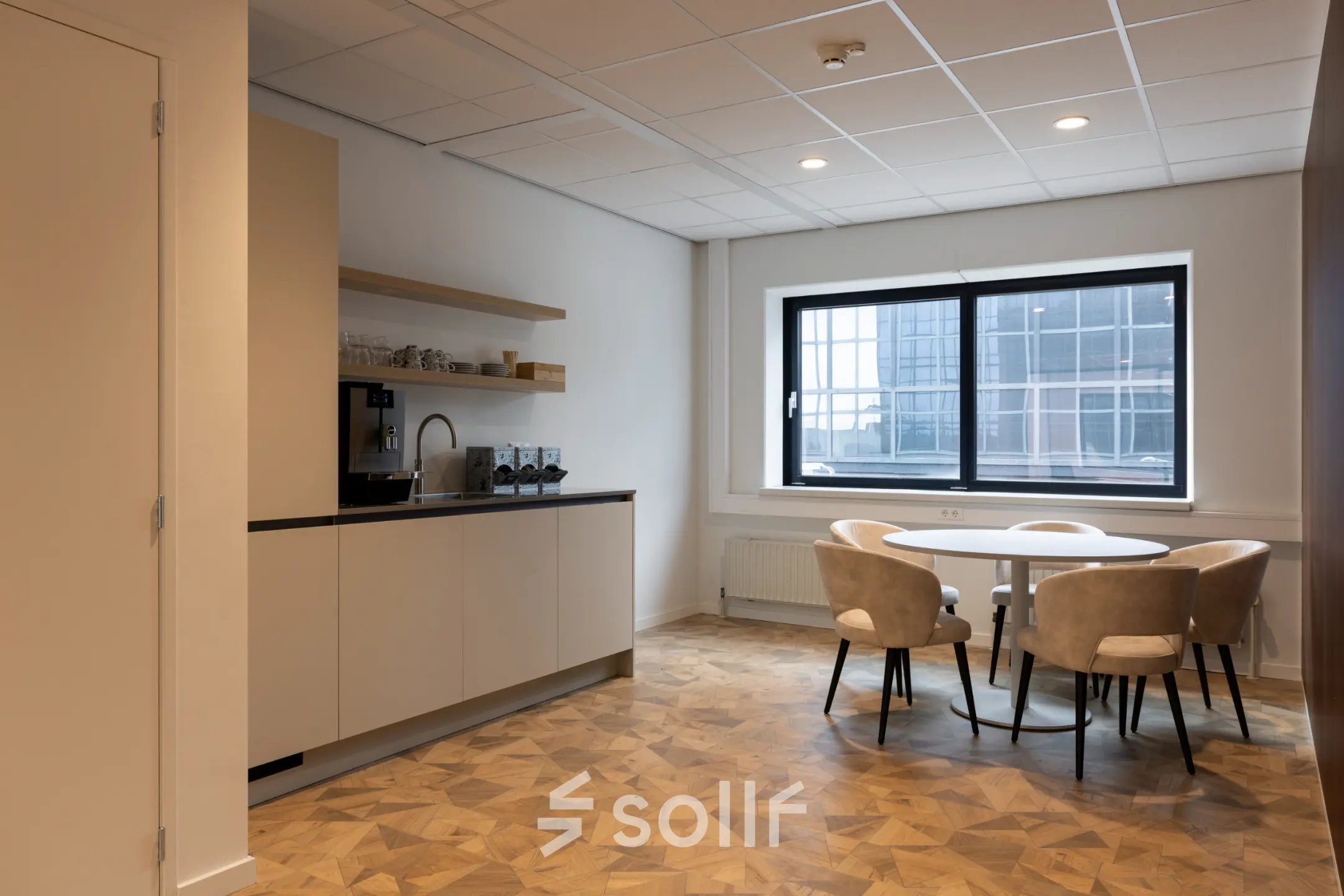 Furnished office space at Essebaan 63, Capelle aan den IJssel, featuring a kitchen area with seating and natural light. Ideal for those seeking office space rental with practical amenities.