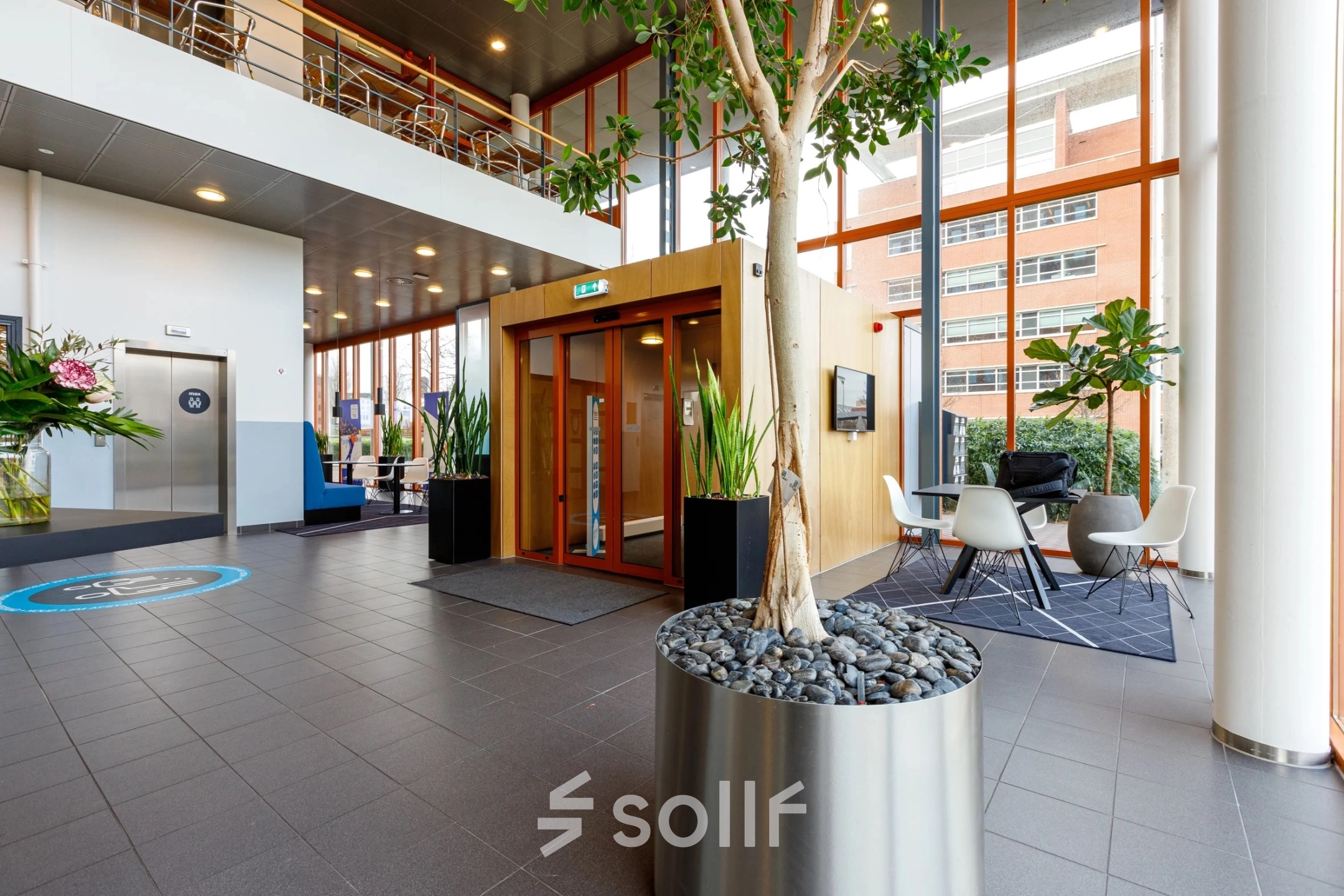 Modern office entrance at Fascinatio Boulevard 562, Capelle aan den IJssel, featuring sleek decor with seating area and plants, ideal for office space rental.
