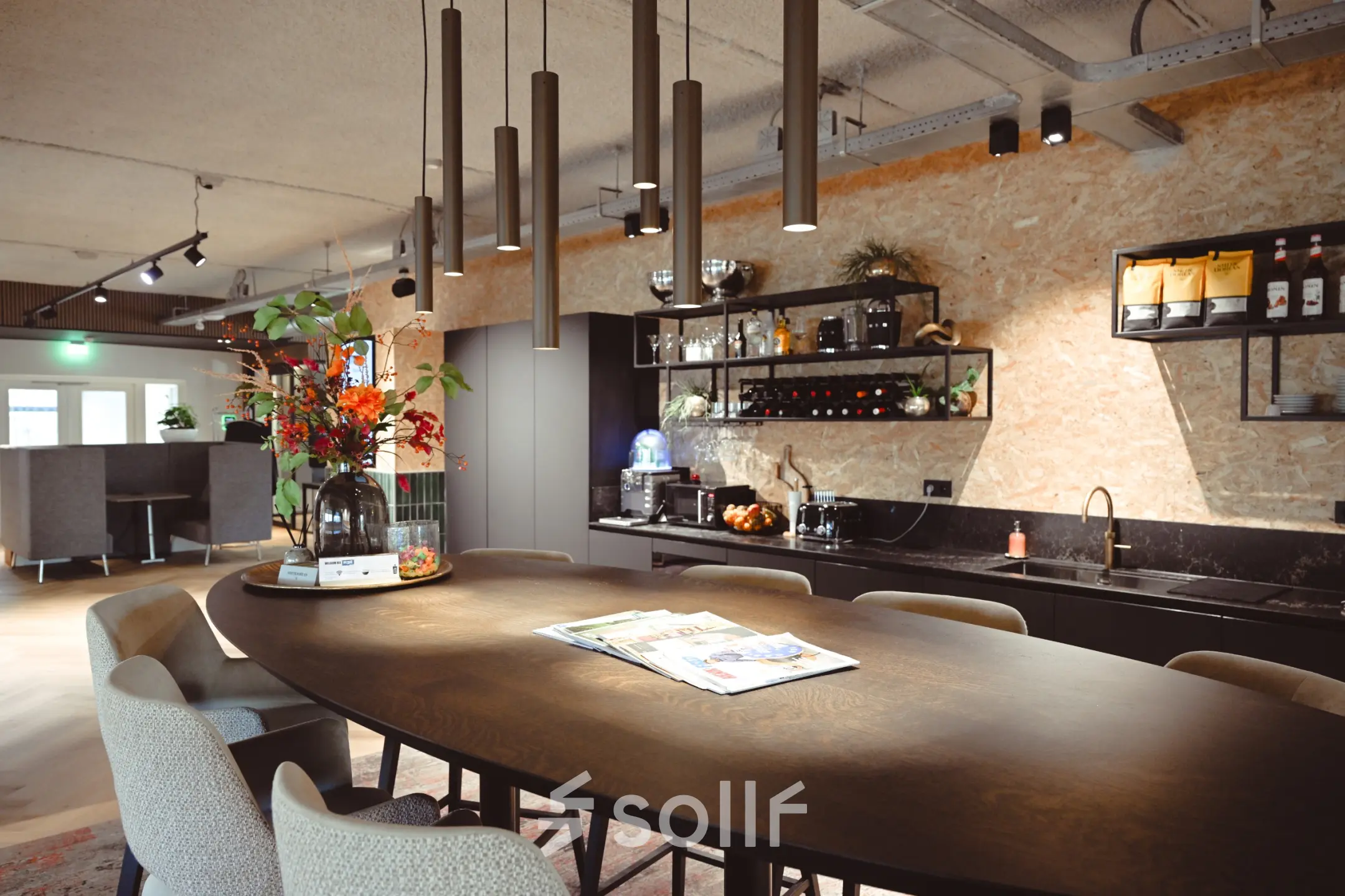 Modern office space at Rivium Quadrant 75, featuring a stylish kitchenette with a large wooden table and contemporary seating, ideal for office space rental.