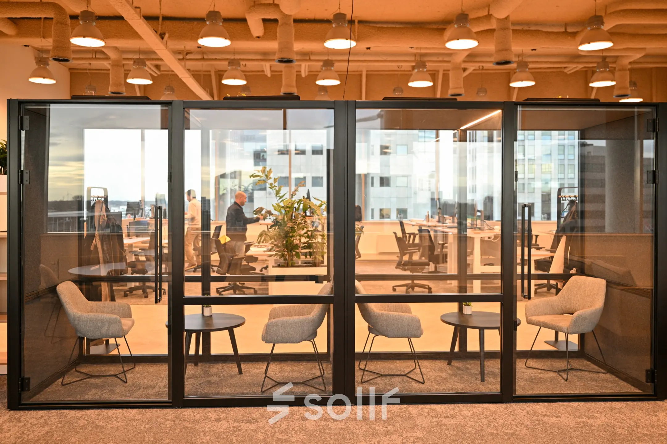 Modern office space to rent at Rivium Quadrant 75, Capelle aan den IJssel, featuring glass-enclosed meeting rooms and collaborative workstations.