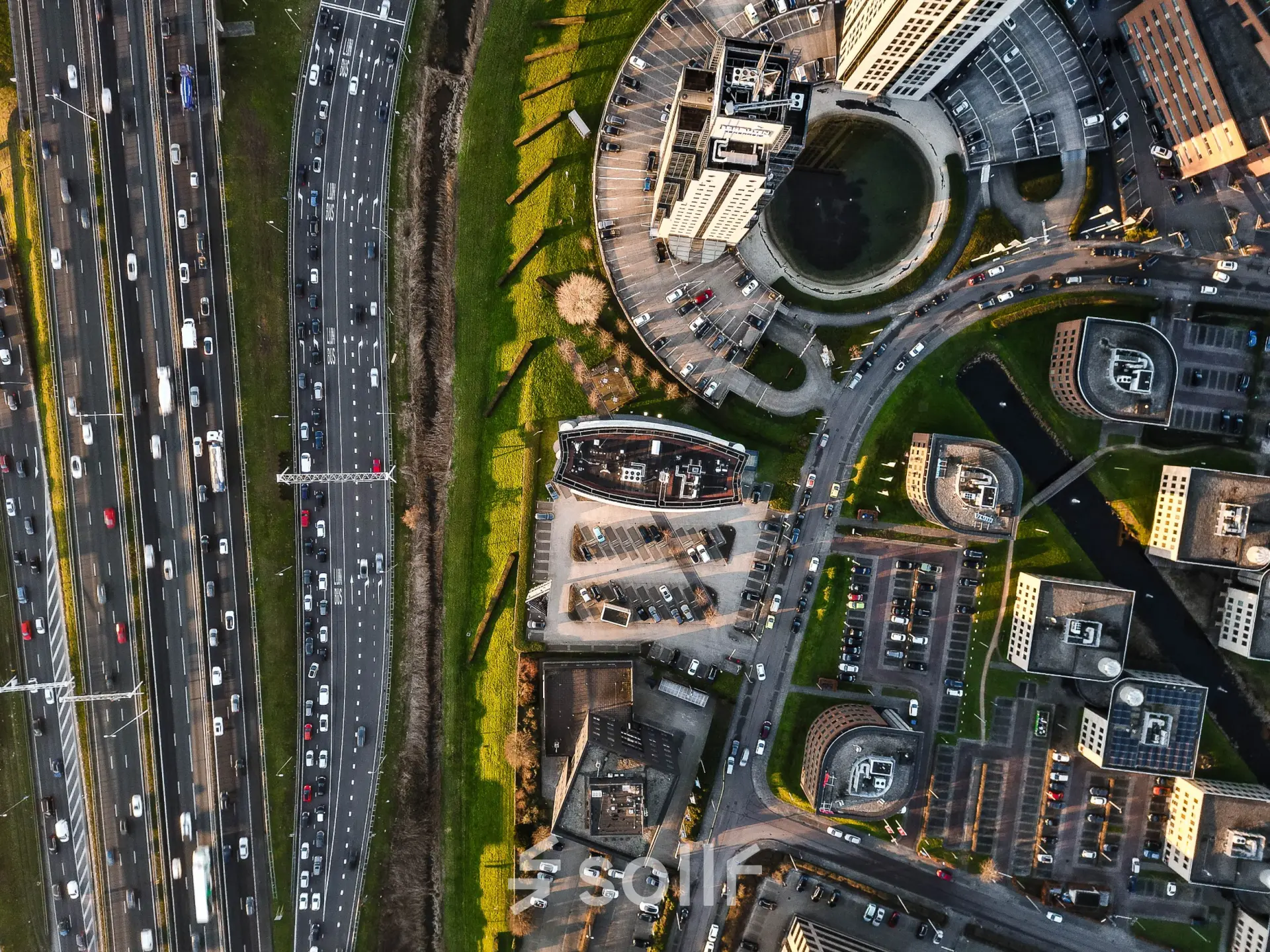 Aerial view of Rivium Quadrant 75 in Capelle aan den IJssel, showcasing office buildings and parking areas.