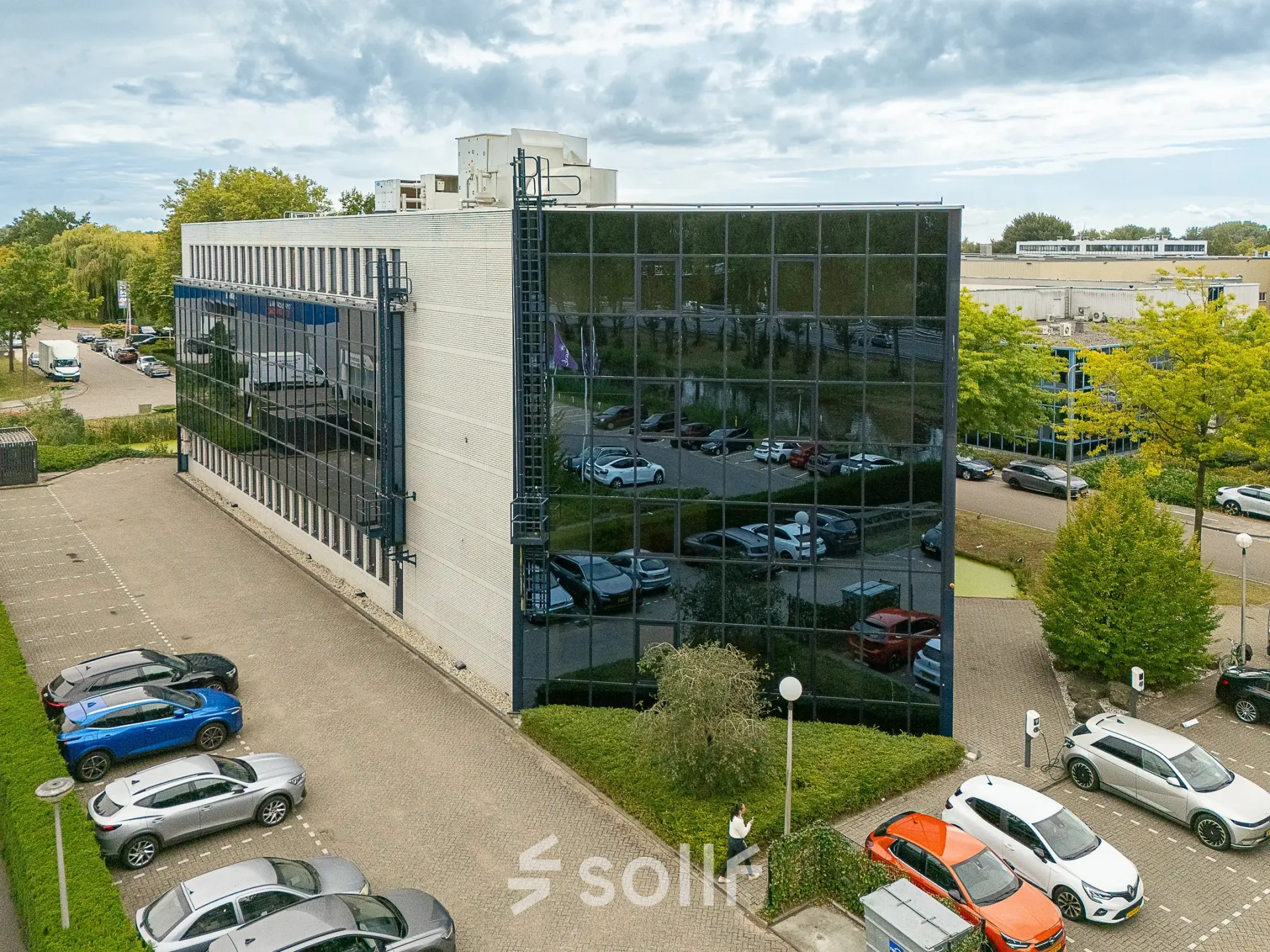 Exterior view of an office building at Vlierbaan 20, Capelle aan den IJssel, showcasing the office space rental location with adjacent parking lot.