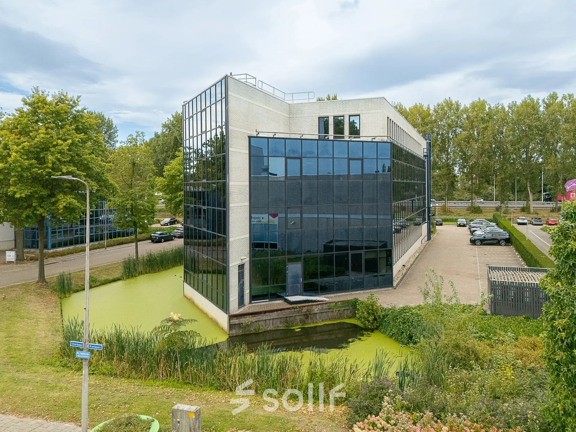 Exterior view of office building at Vlierbaan 20, Capelle aan den IJssel, perfect for office space rental, surrounded by greenery and parking area.