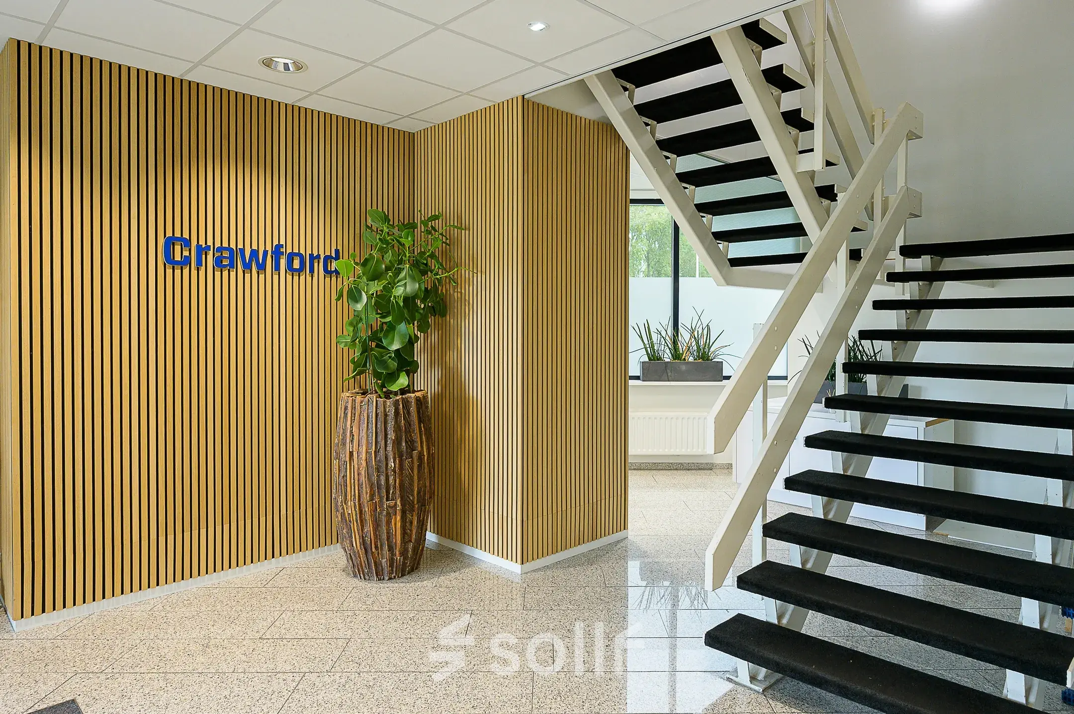 Modern office entrance at Vlierbaan 20, Capelle aan den IJssel, with a staircase and decorative plants, available for office space rental.