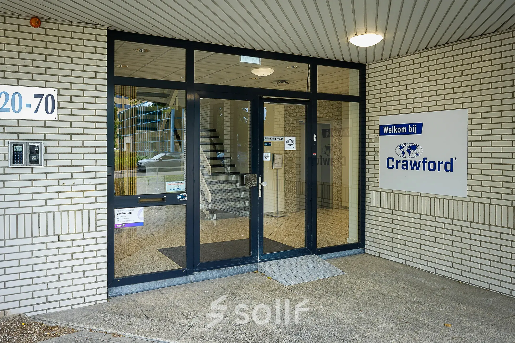 Entrance of an office building at Vlierbaan 20, Capelle aan den IJssel, featuring a modern glass door and a welcome sign, ideal for office space rental.