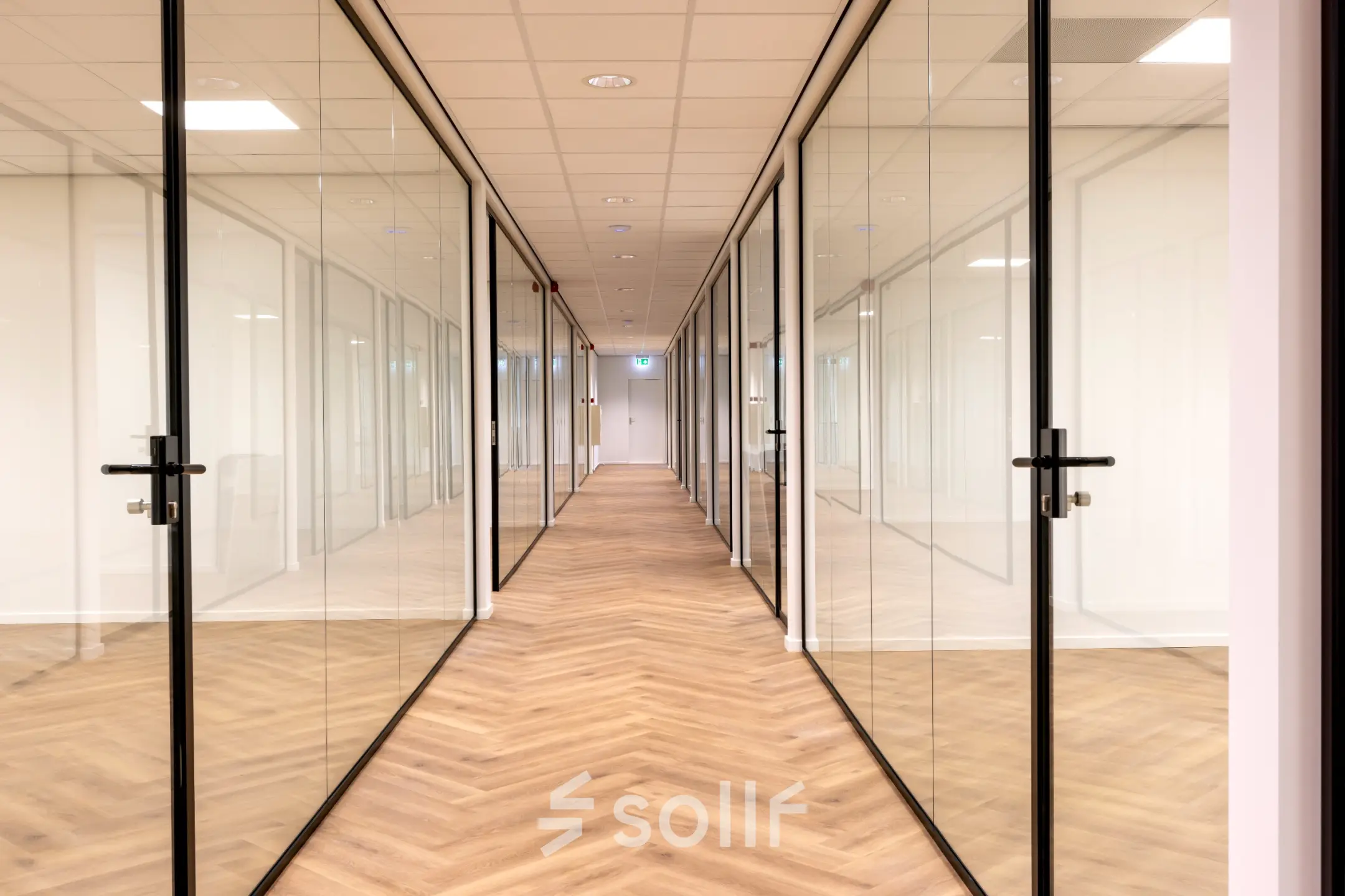 Bright hallway in an office space at Vlierbaan 20, Capelle aan den IJssel, featuring glass doors leading to various offices available for rent.