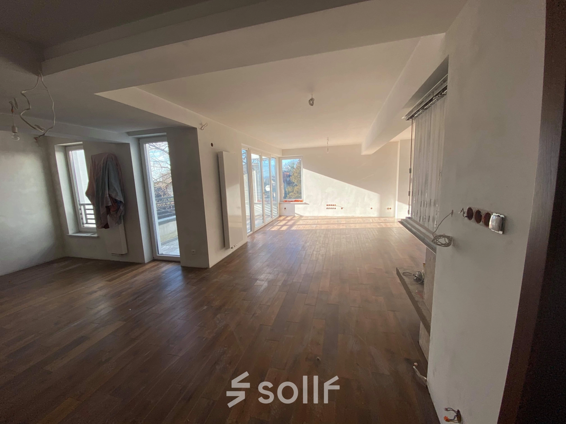 Unfurnished office space featuring wooden floors and large windows offering ample natural light, perfect for office space rental. Located in Cracow Podgorze Duchackie, ideal for those seeking rent office space.