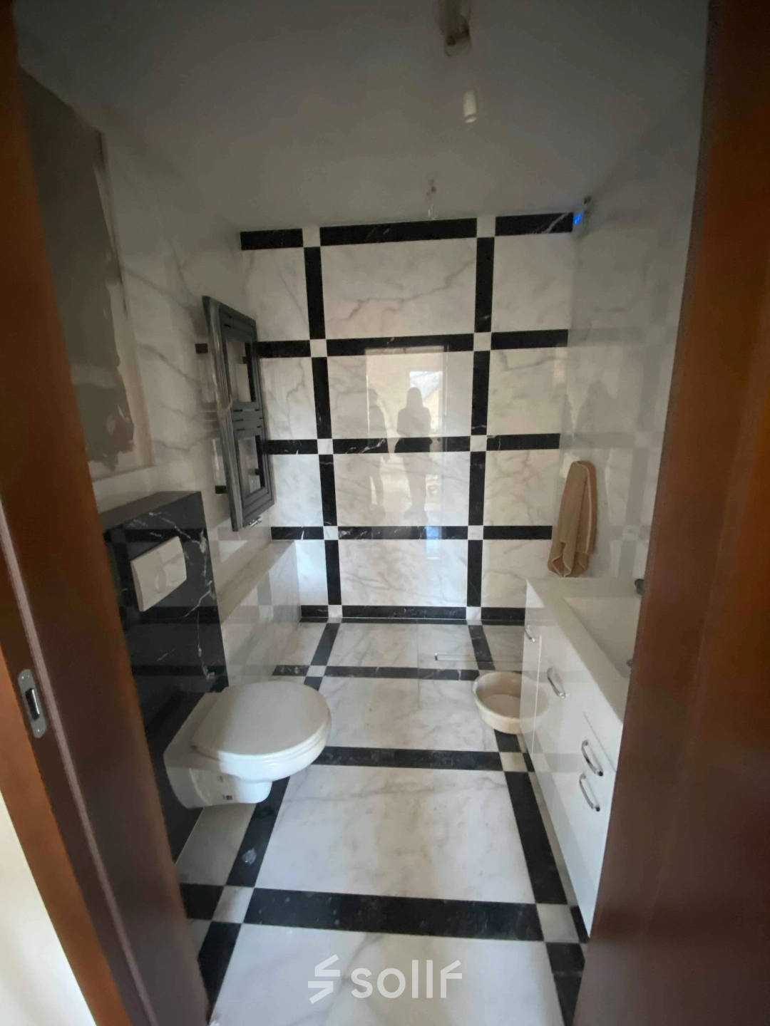 A restroom at Jastrzębia 24, Cracow Podgorze Duchackie, includes modern amenities with a stylish black and white tile design, ideal for an office space rental.