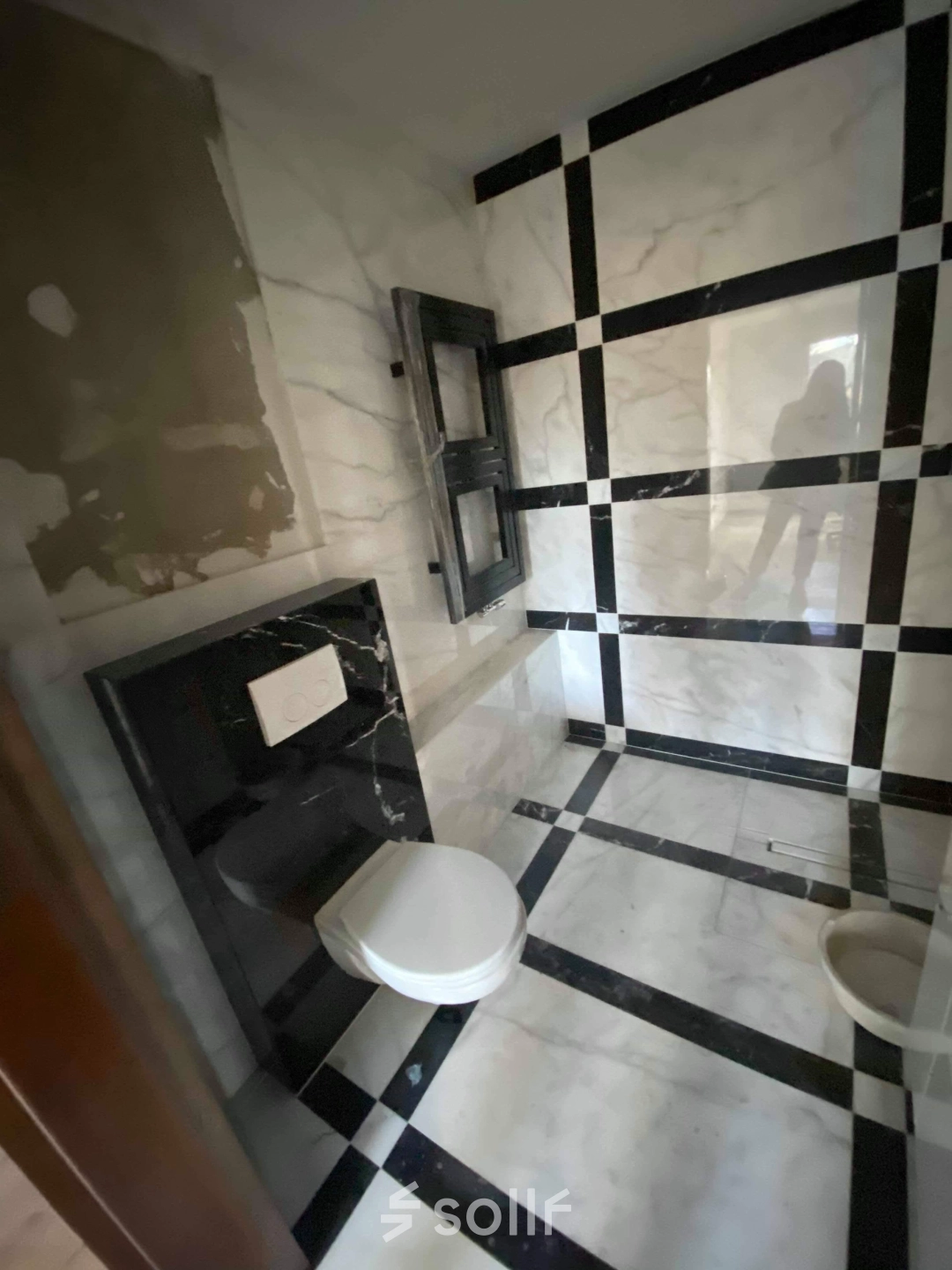 A tiled restroom in an office to rent at Jastrzębia 24, Cracow Podgorze Duchackie. The space features black and white marble tiles, a toilet, and a modern design.