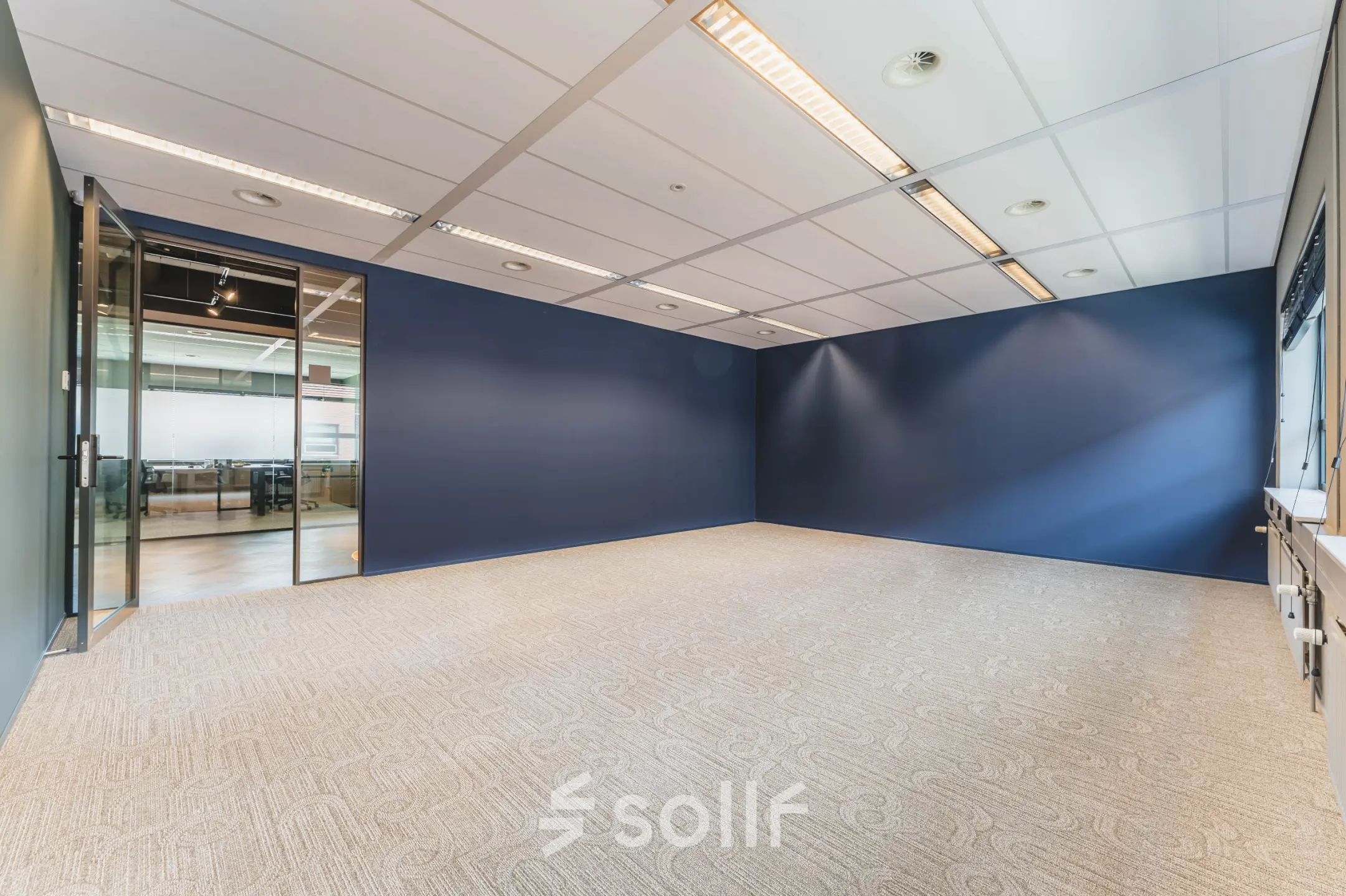 Spacious, unfurnished office space available for rent at Rijnzathe 12, De Meern, featuring a modern interior with blue walls and ample lighting.