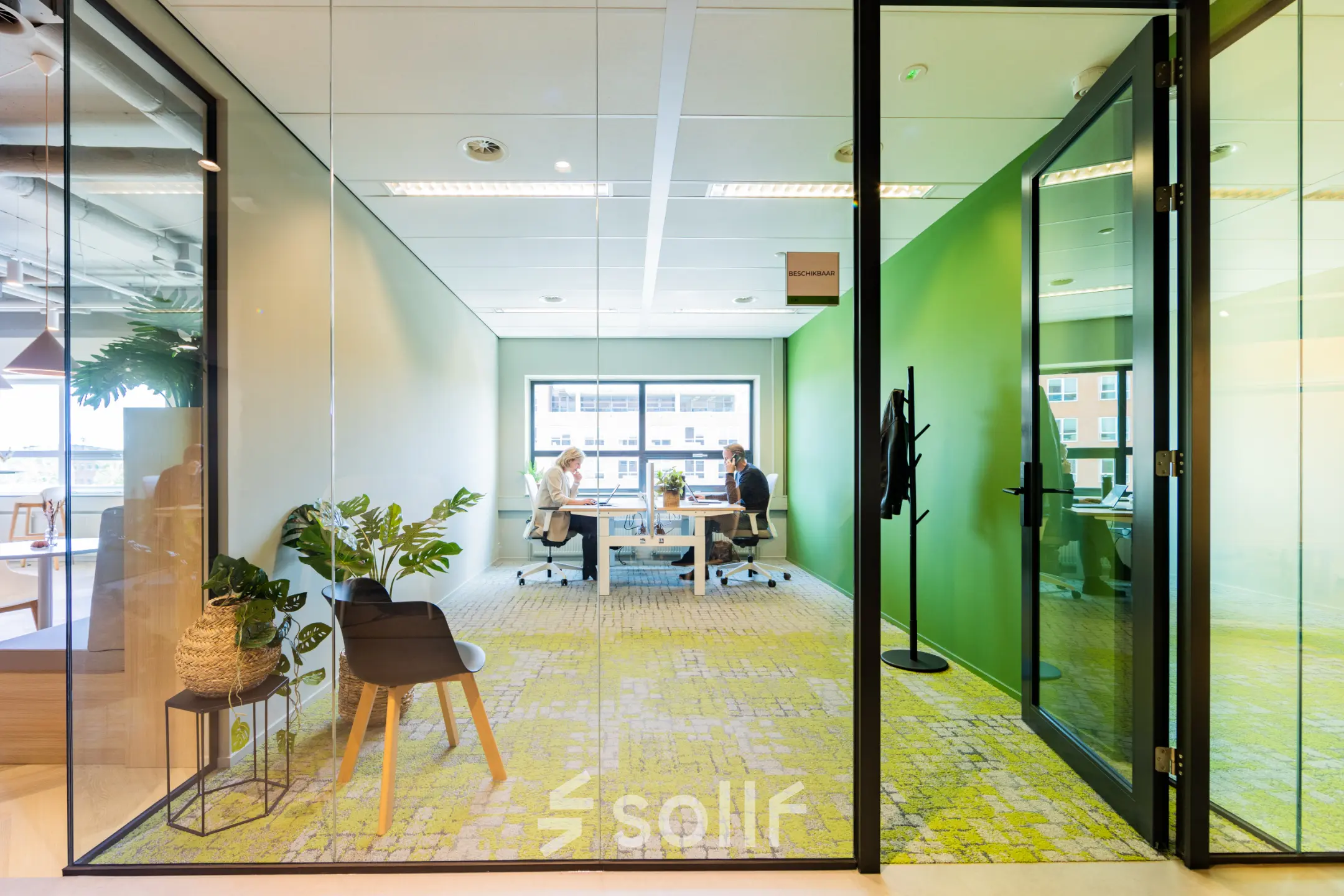 Modern office space for rent at Rijnzathe 12, De Meern, featuring a bright interior with two people collaborating at desks.