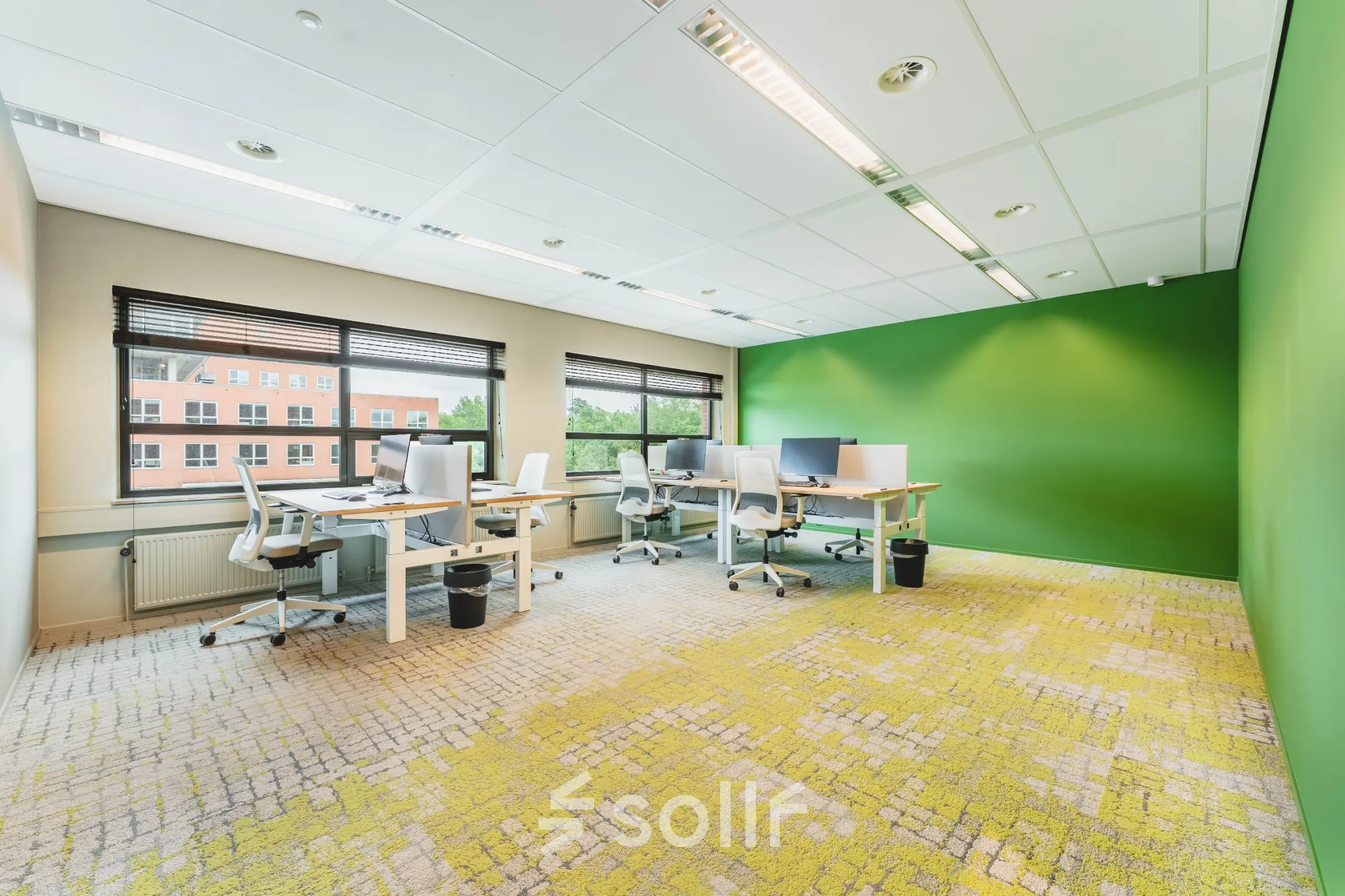 Bright office space at Rijnzathe 12, De Meern featuring several desks and chairs against a vibrant green wall, perfect for rent office space seekers.