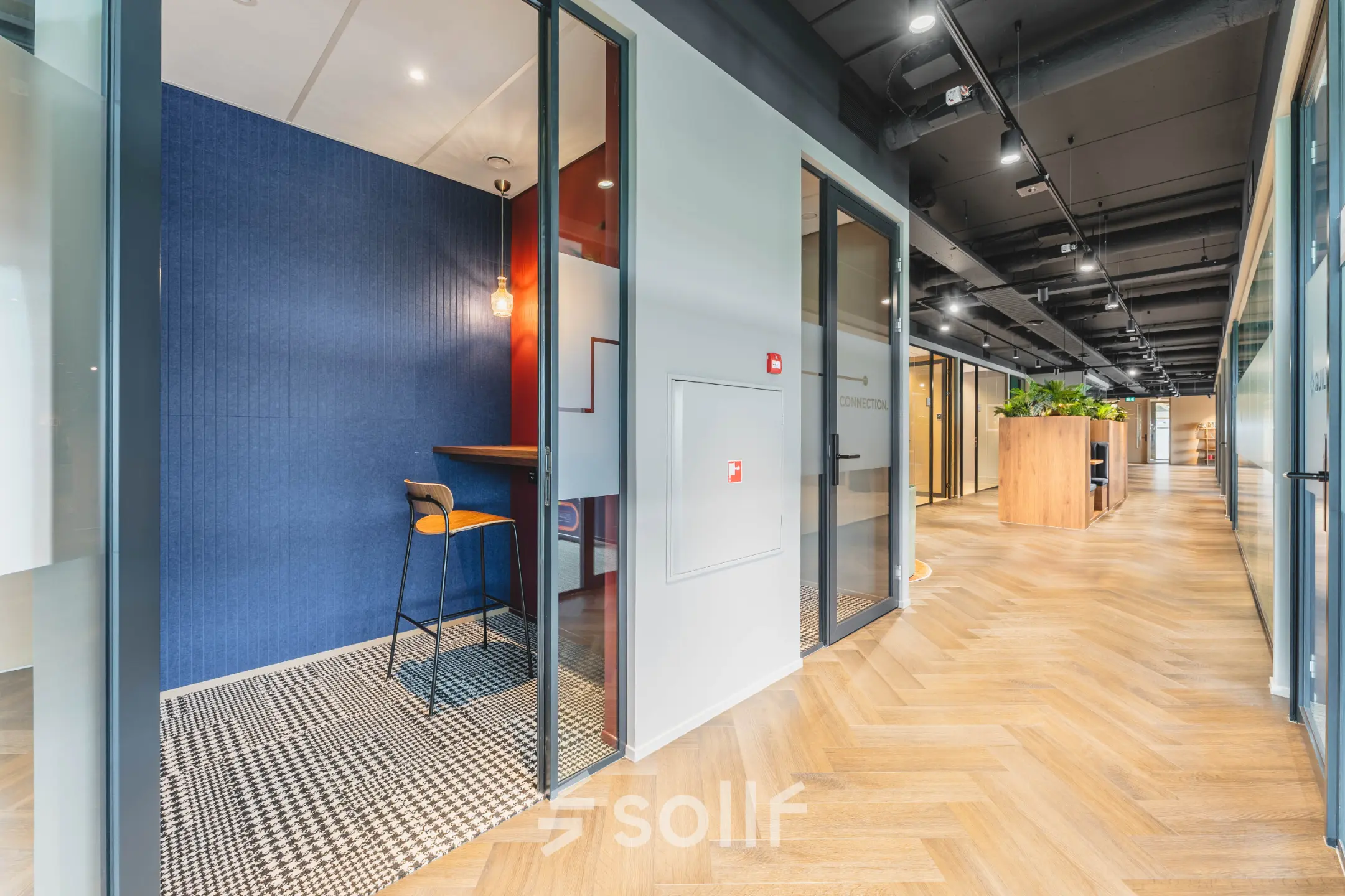 Modern hallway with glass-walled offices at Rijnzathe 12, ideal for office space rental in De Meern.