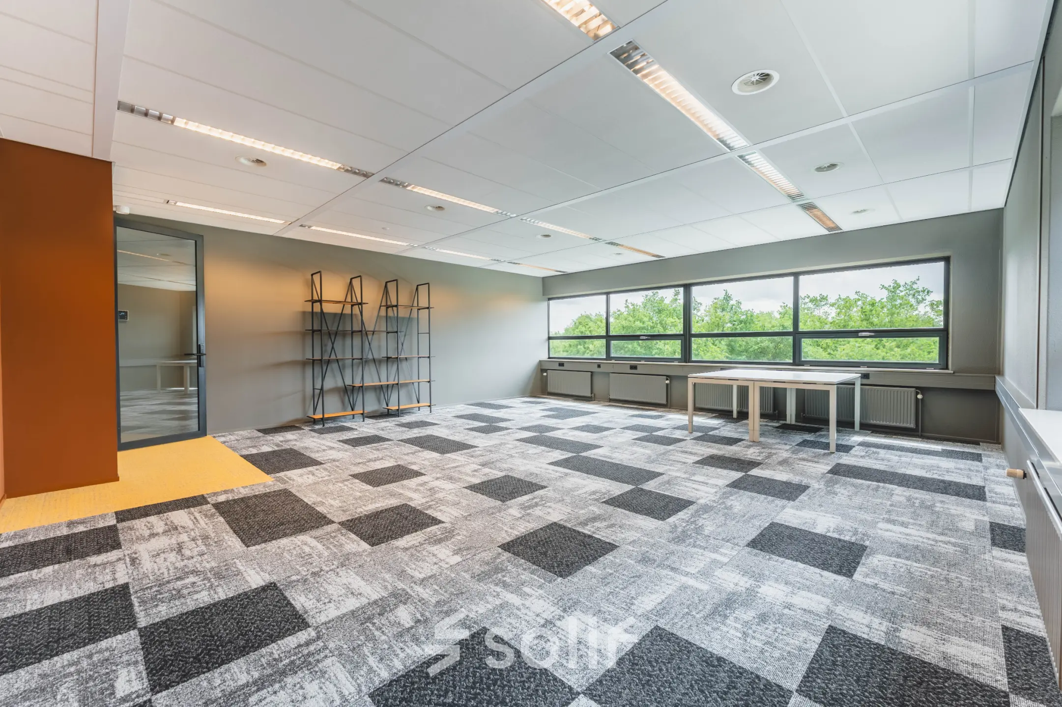 Unfurnished office space with large windows at Rijnzathe 12, De Meern, available for rent. The room features patterned carpeting and ample natural light, perfect for transforming into a dynamic workspace.