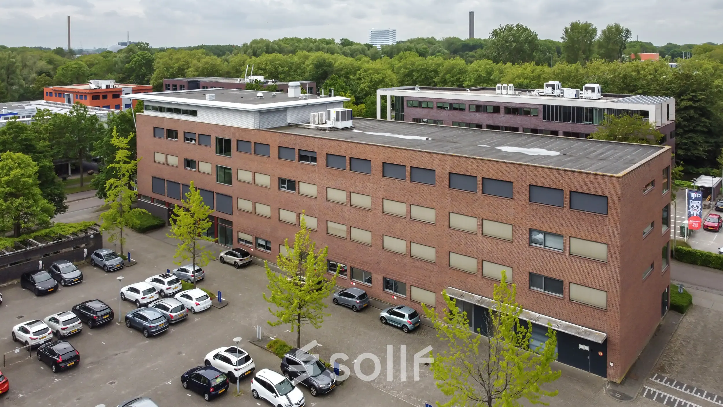 Exterior view of an office building at Delftechpark 9, Delft with an adjacent parking area, ideal for office space rental.